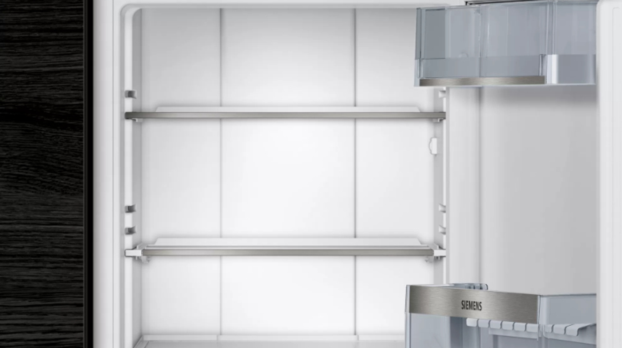 Empty refrigerator interior with shelves and a Siemens logo.