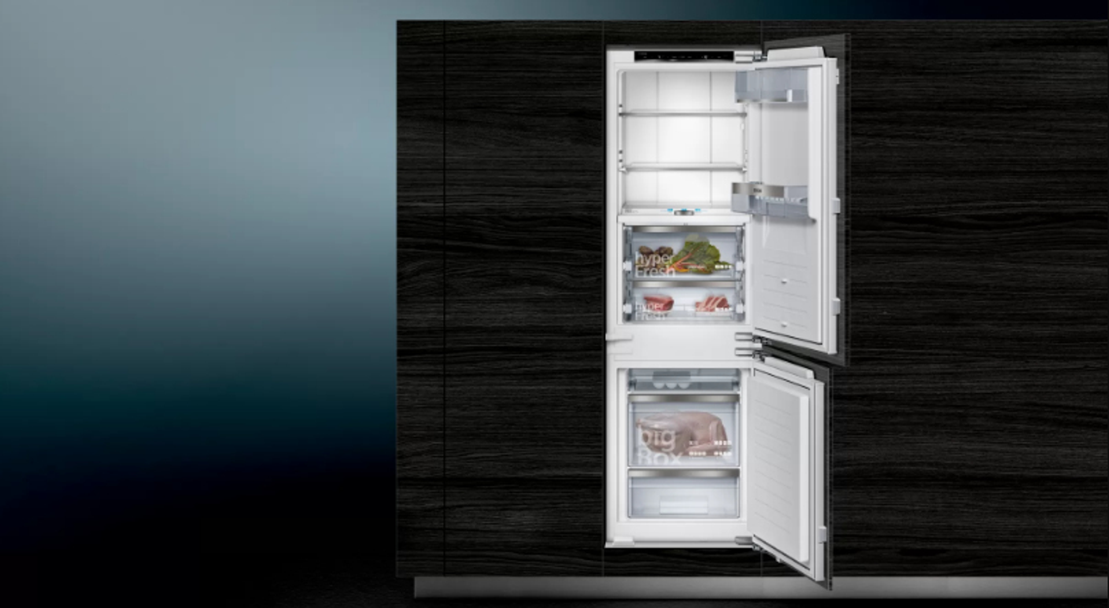 Opened refrigerator with contents. Top section has food, bottom section has freezer.