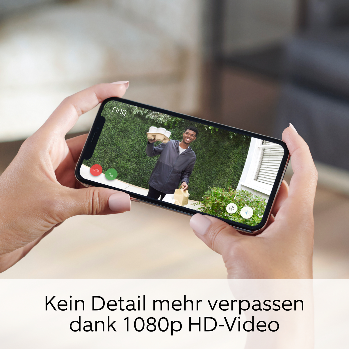 Hände halten ein Telefon, das einen Videoanruf eines Mannes mit Paketen zeigt.