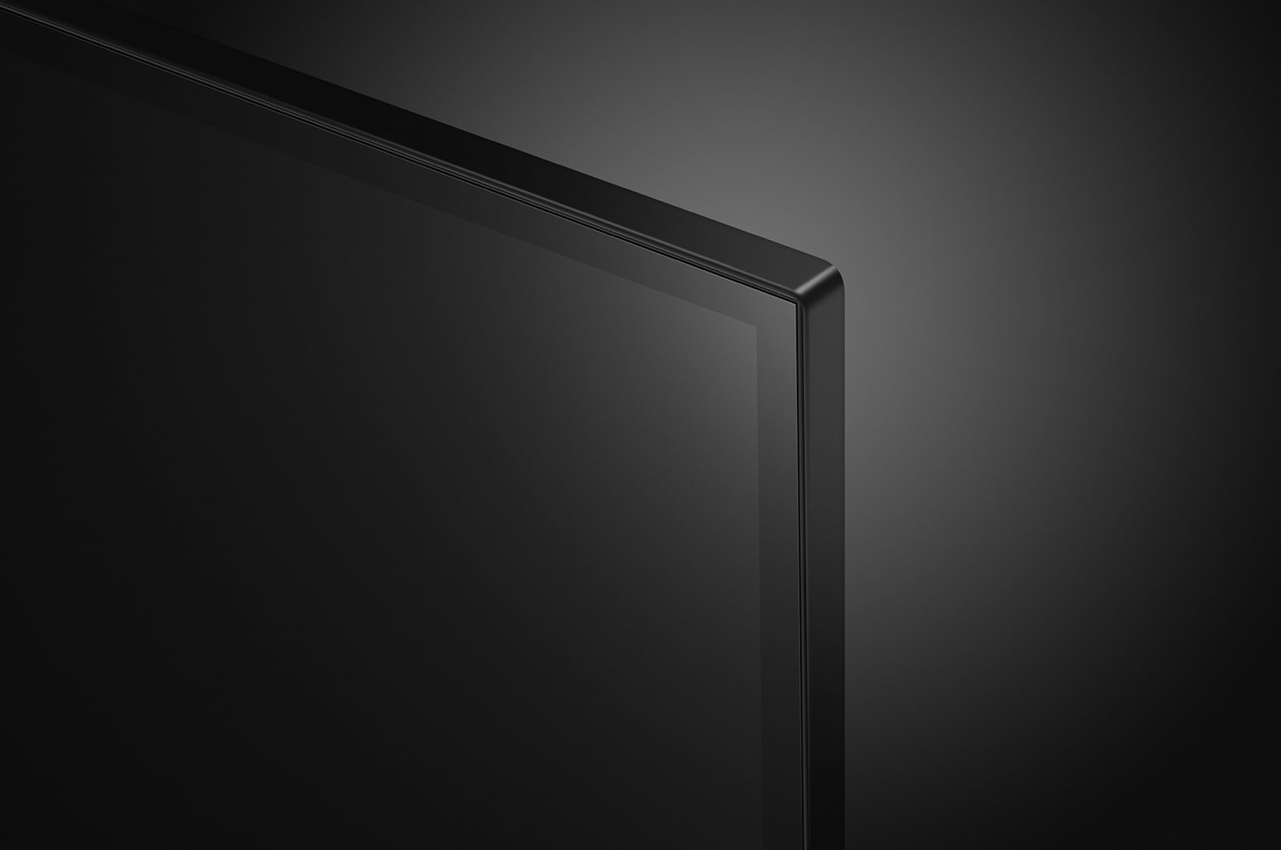 Czarny róg telewizora, czarna ramka, odblaskowy ekran, ciemne tło.