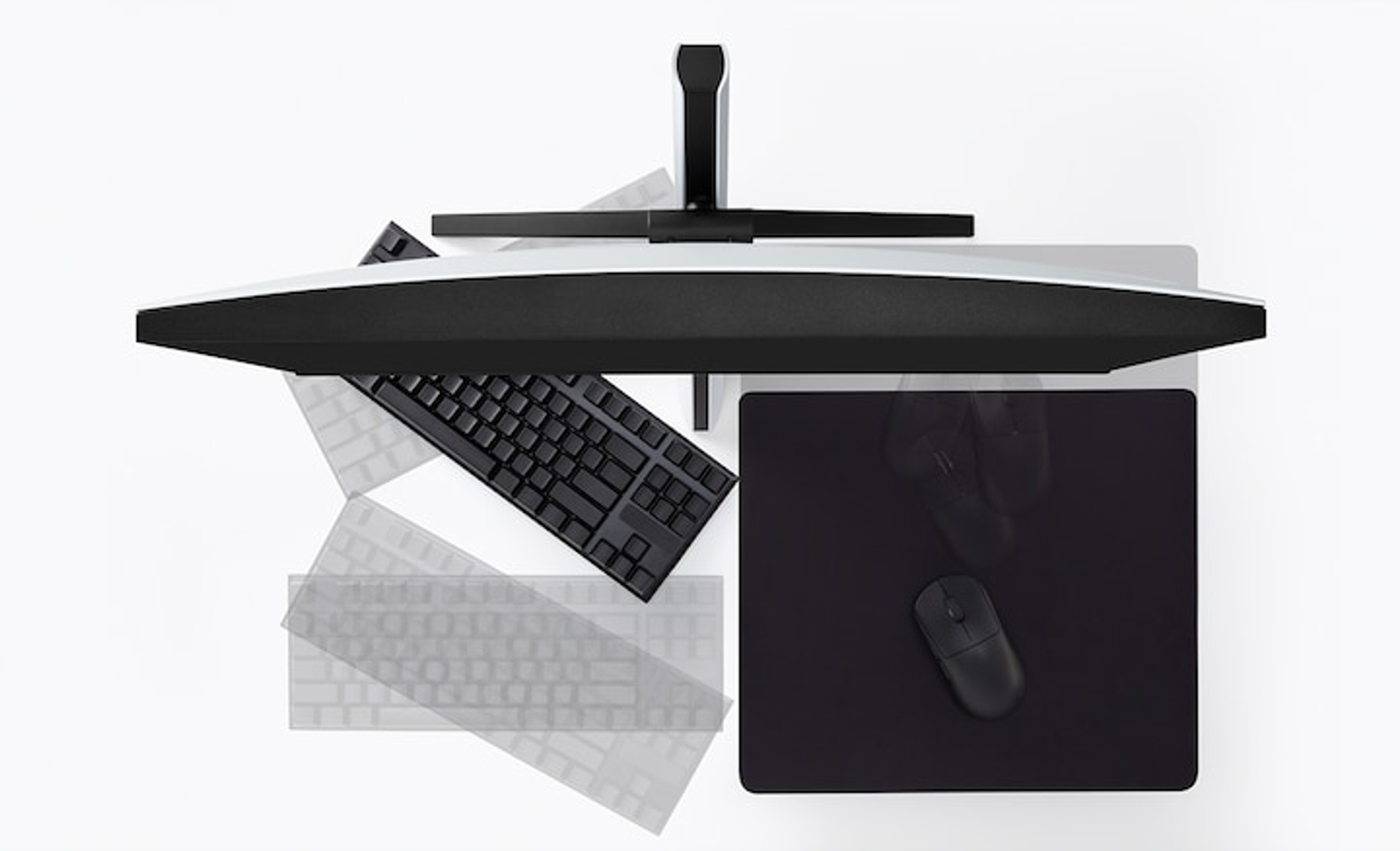 Draufsicht auf einen Schreibtisch mit Monitor, Tastatur, Maus und Mauspad auf einer weißen Oberfläche.