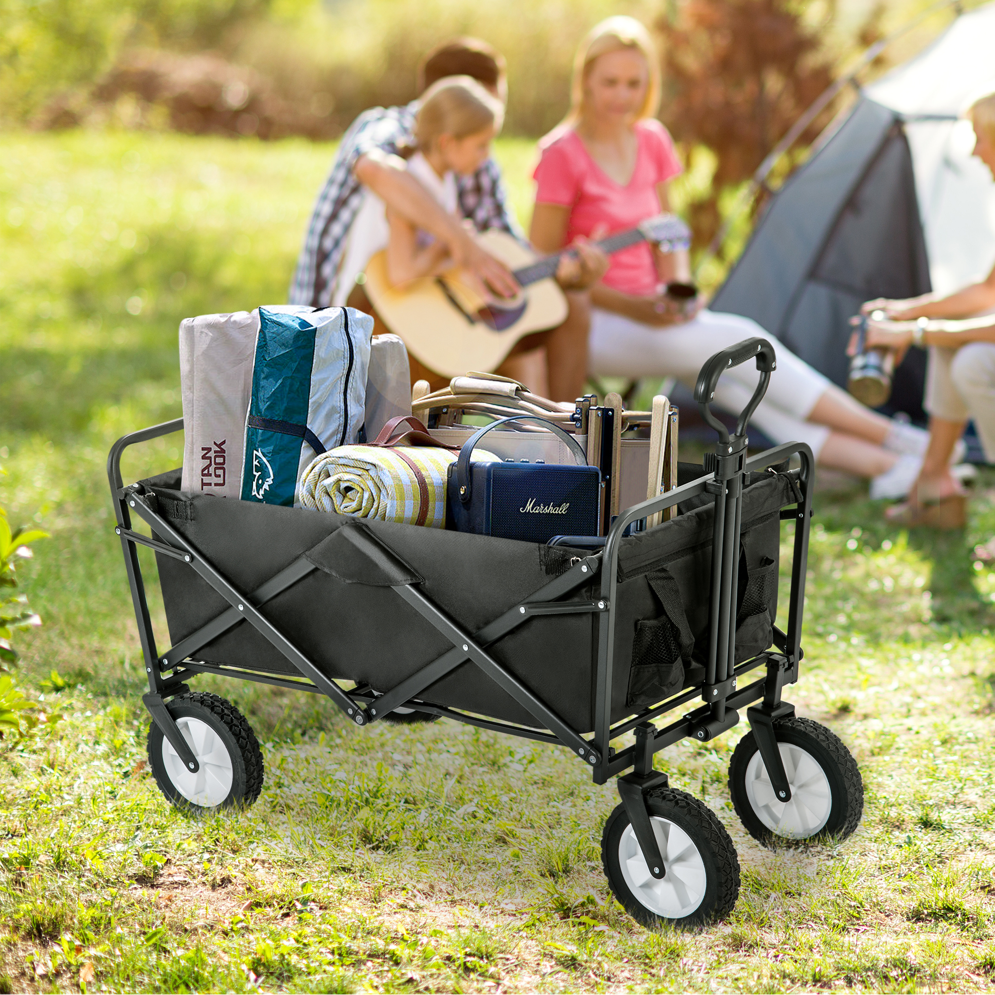 Schwarzer Utility-Wagen mit Campingausrüstung, Familie im Hintergrund.