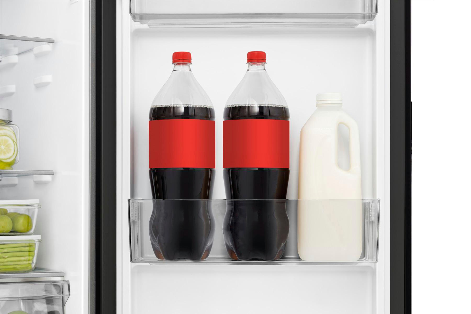 Im Kühlschrank stehen zwei Cola-Flaschen mit roten Etiketten und ein Milchkrug auf einem Regal.