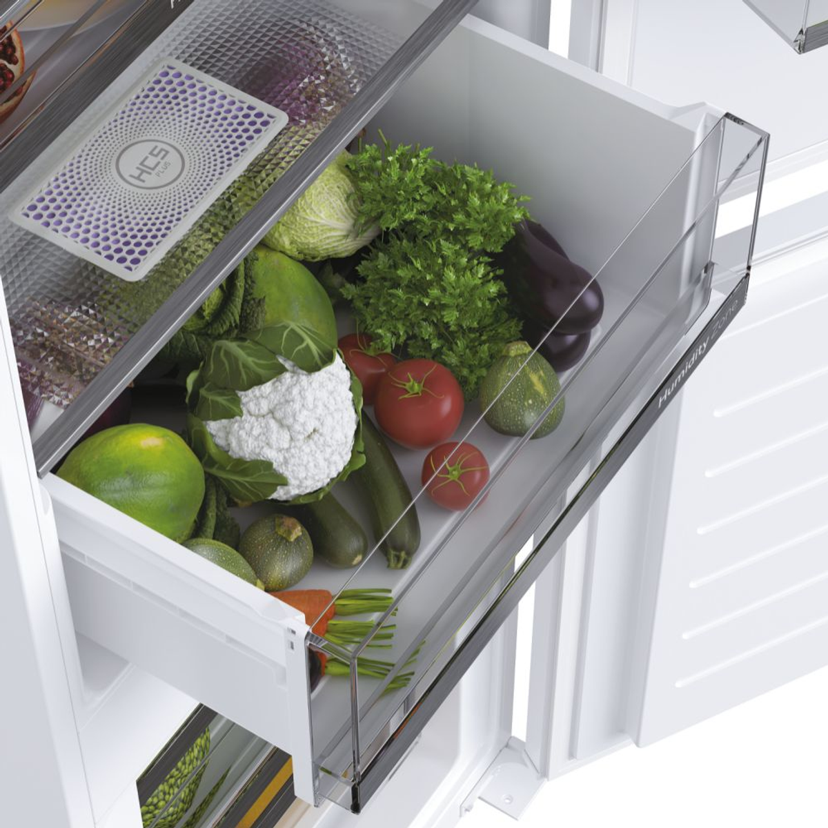 Cassetto del frigorifero pieno di verdure, tra cui cavolfiori, pomodori e zucchine.