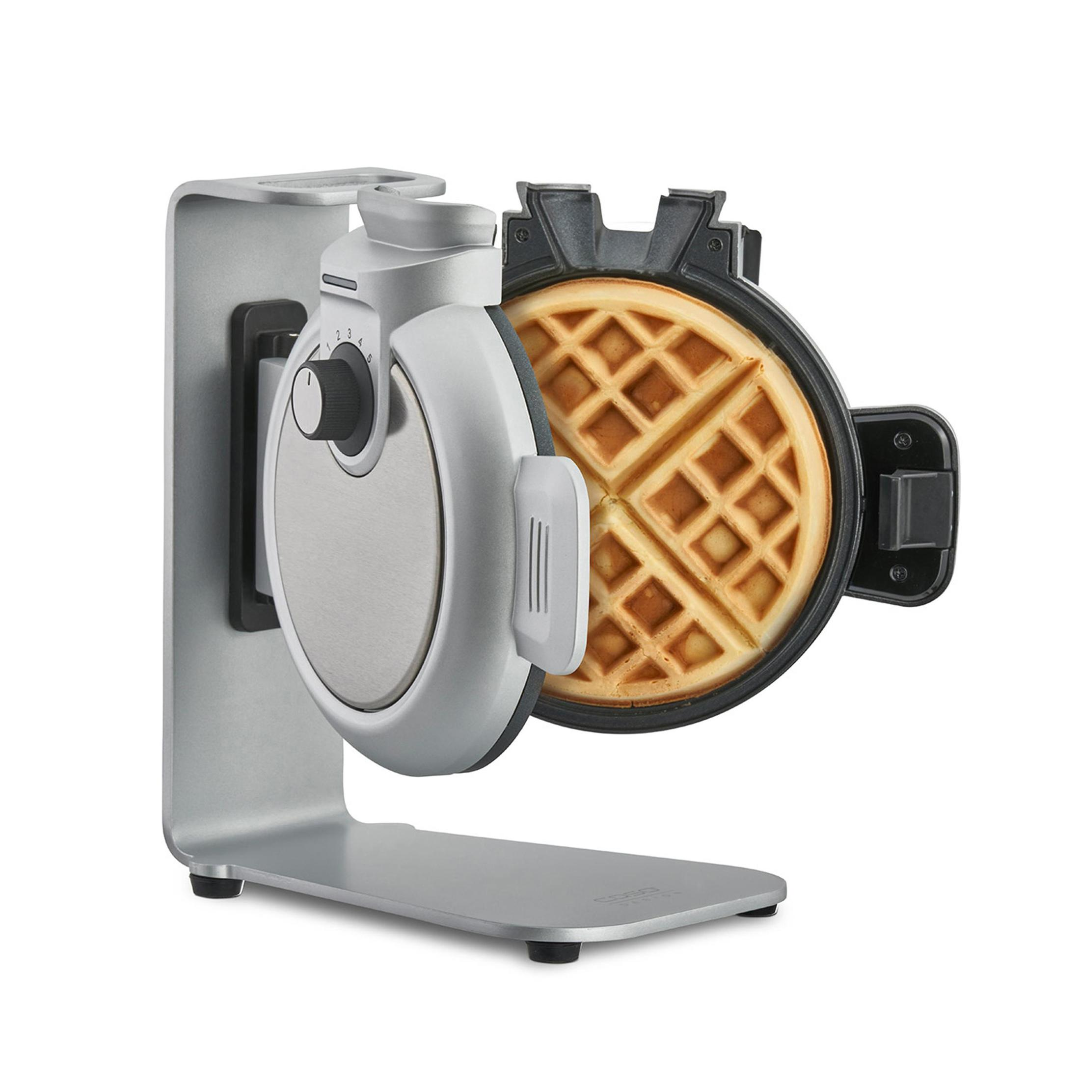 Silberner Waffeleisen mit Waffel. Es ist geöffnet und zeigt die gebackene Waffel.