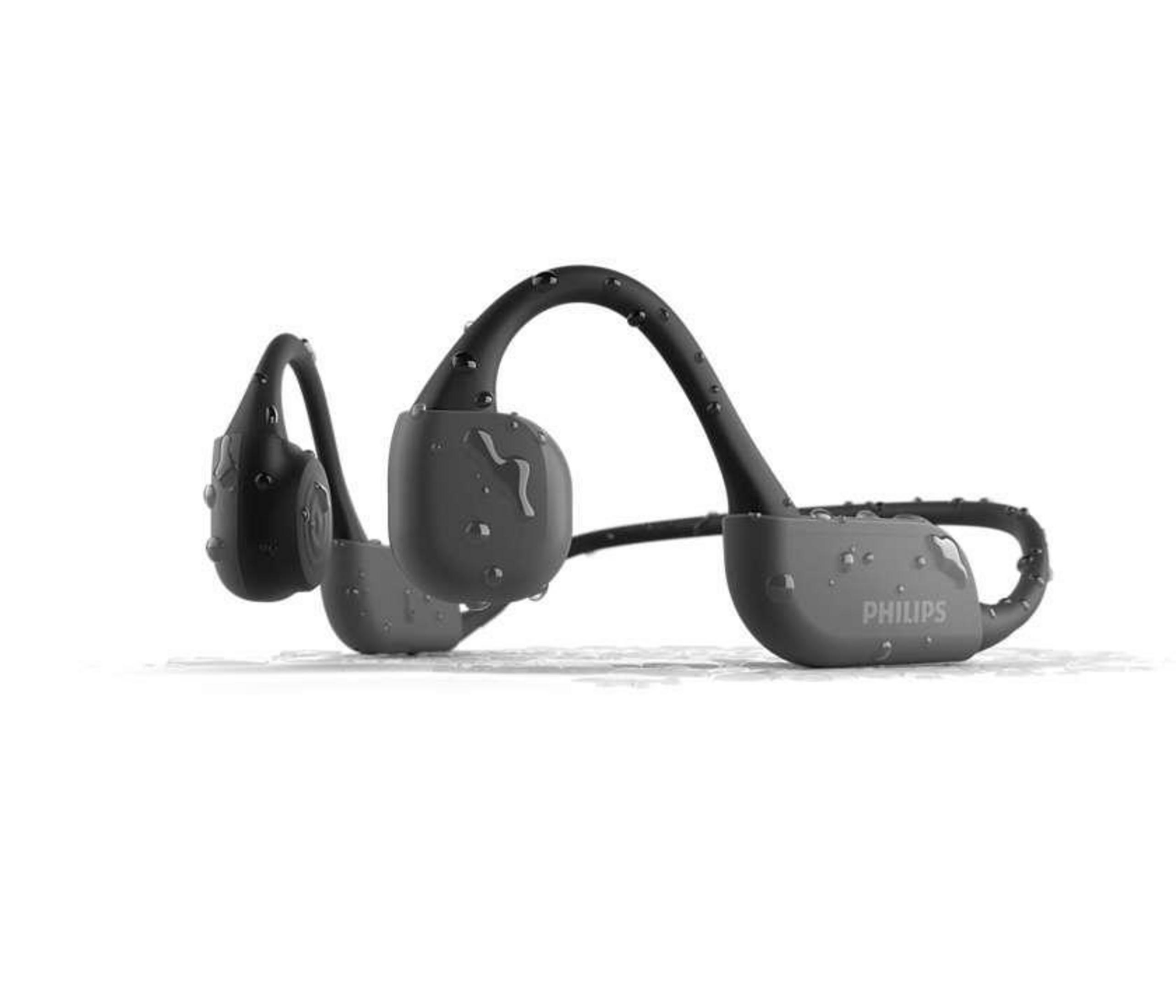 Auriculares de conducción ósea Philips negros con gotas de agua. Sobre una superficie blanca.