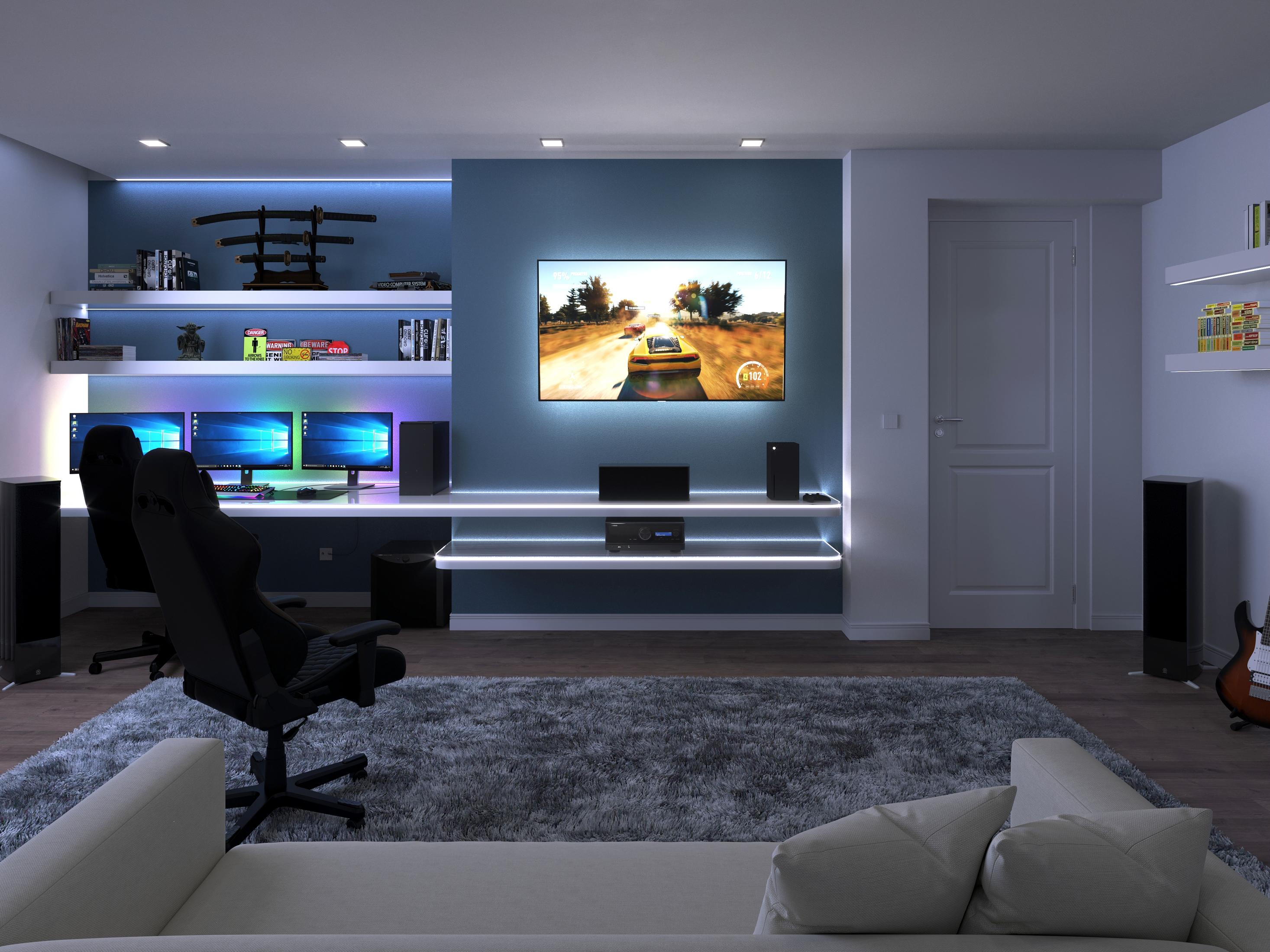 Gaming-Raum mit mehreren Monitoren, Gaming-Stuhl und Couch. Ein Fernseher ist an einer blauen Wand montiert.