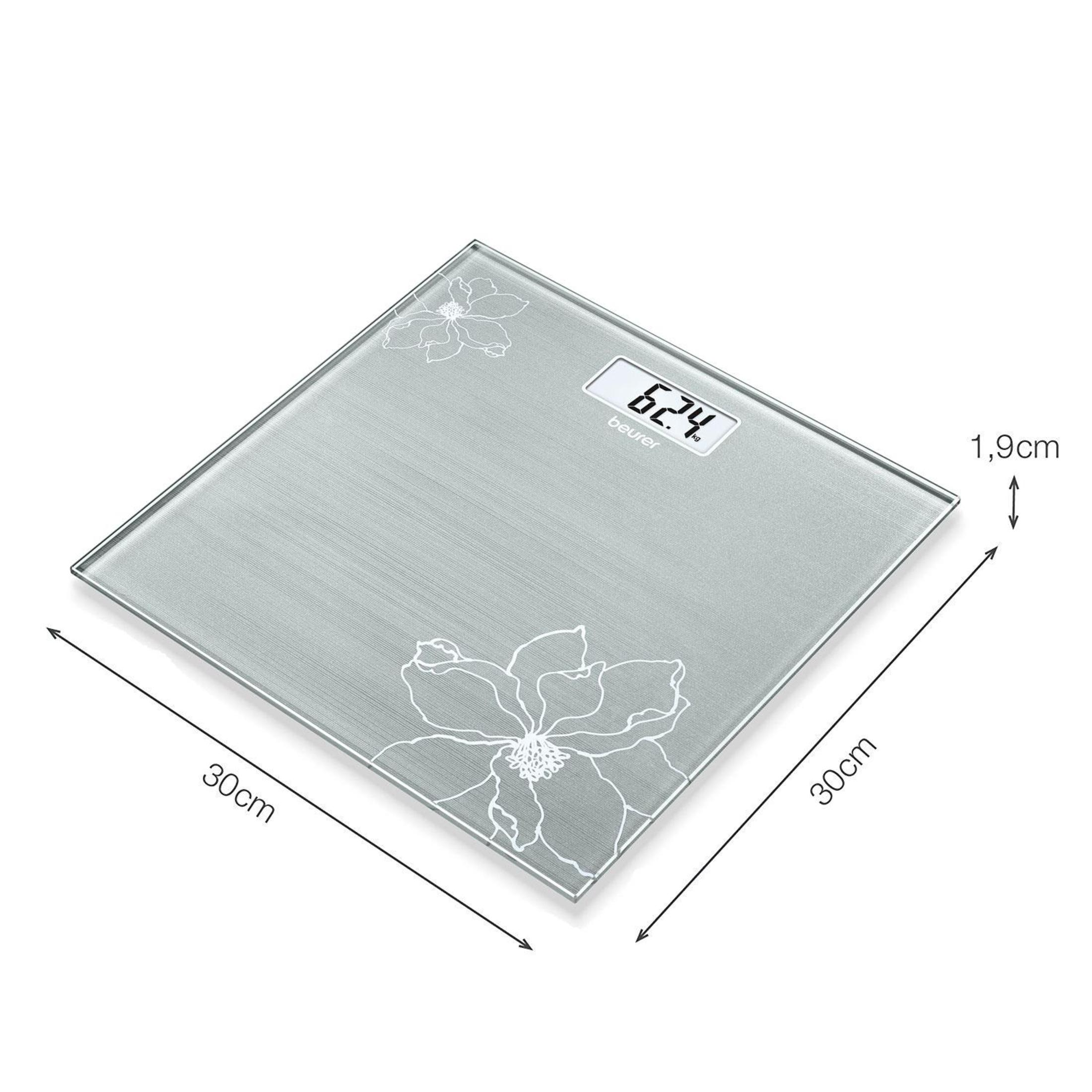 Eine digitale Waage, weißer Hintergrund. Die Waage ist quadratisch mit floralen Designs. Sie zeigt das Gewicht 62,4.