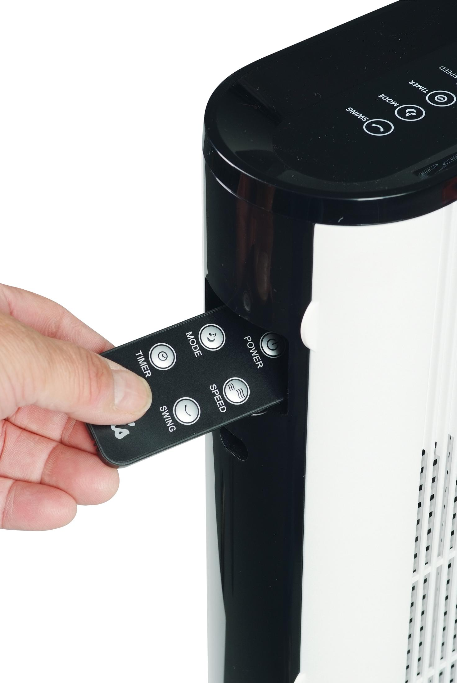 Eine Hand, die eine Fernbedienung in einen weiß-schwarzen Ventilator steckt.