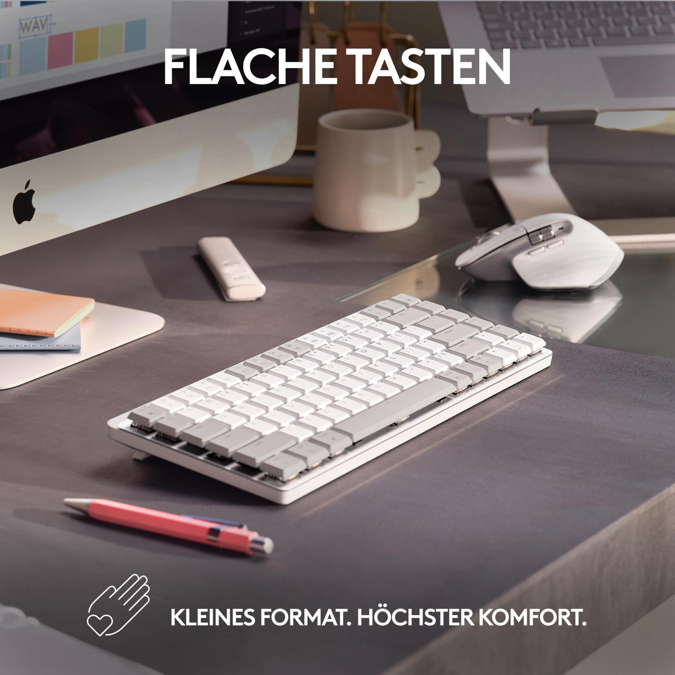 Una tastiera bianca con tasti grigi è appoggiata su una superficie grigia. C'è un mouse e una penna sulla superficie.