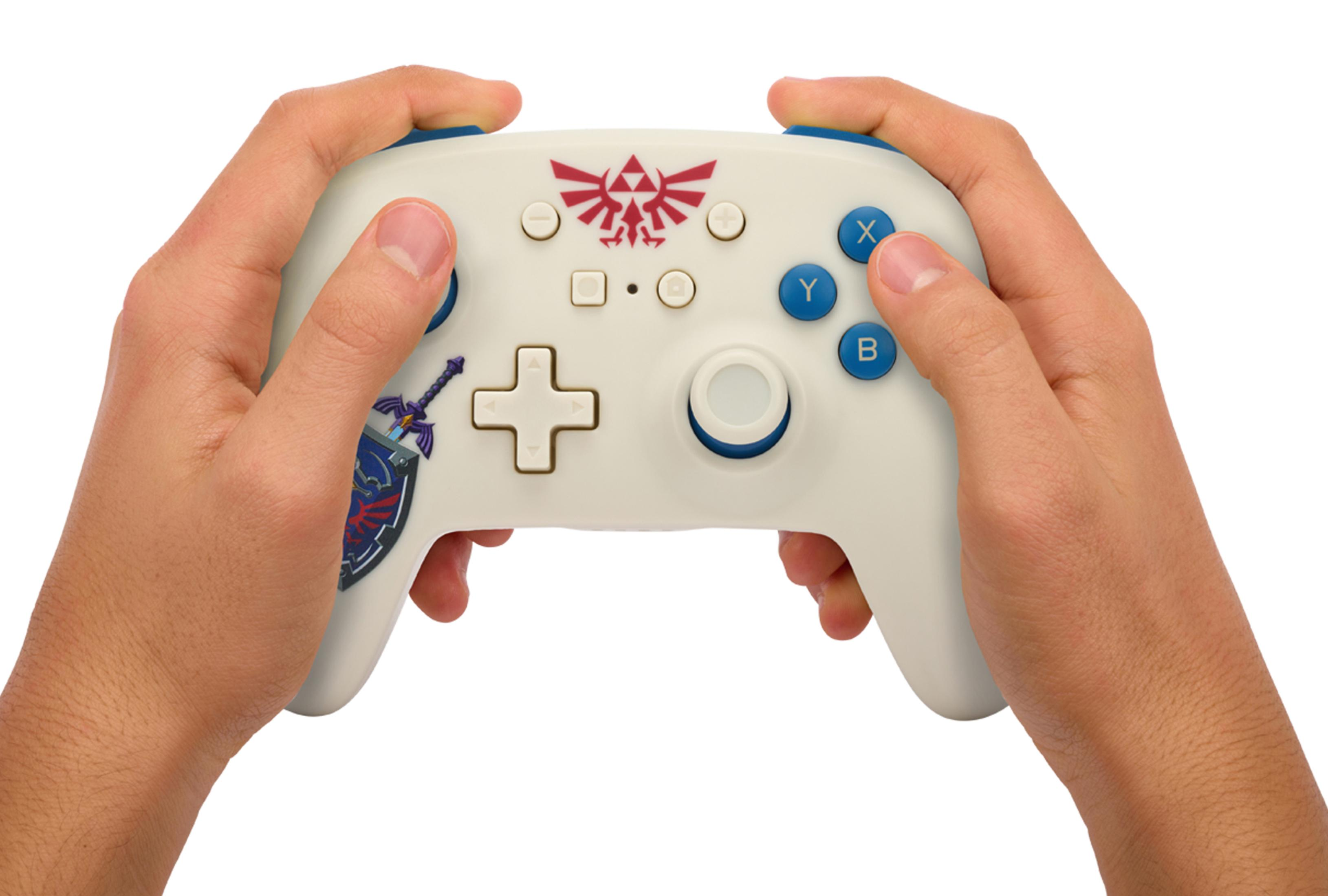 Biały kontroler Nintendo Switch trzymany w dwóch dłoniach. Niebieskie przyciski i symbol Zelda.