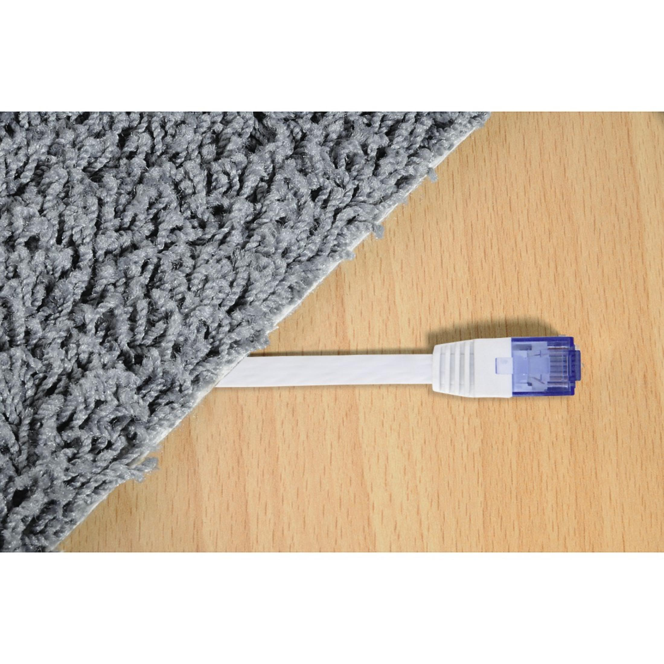 Cavo Ethernet bianco collegato a una porta blu, appoggiato su legno e moquette grigia.