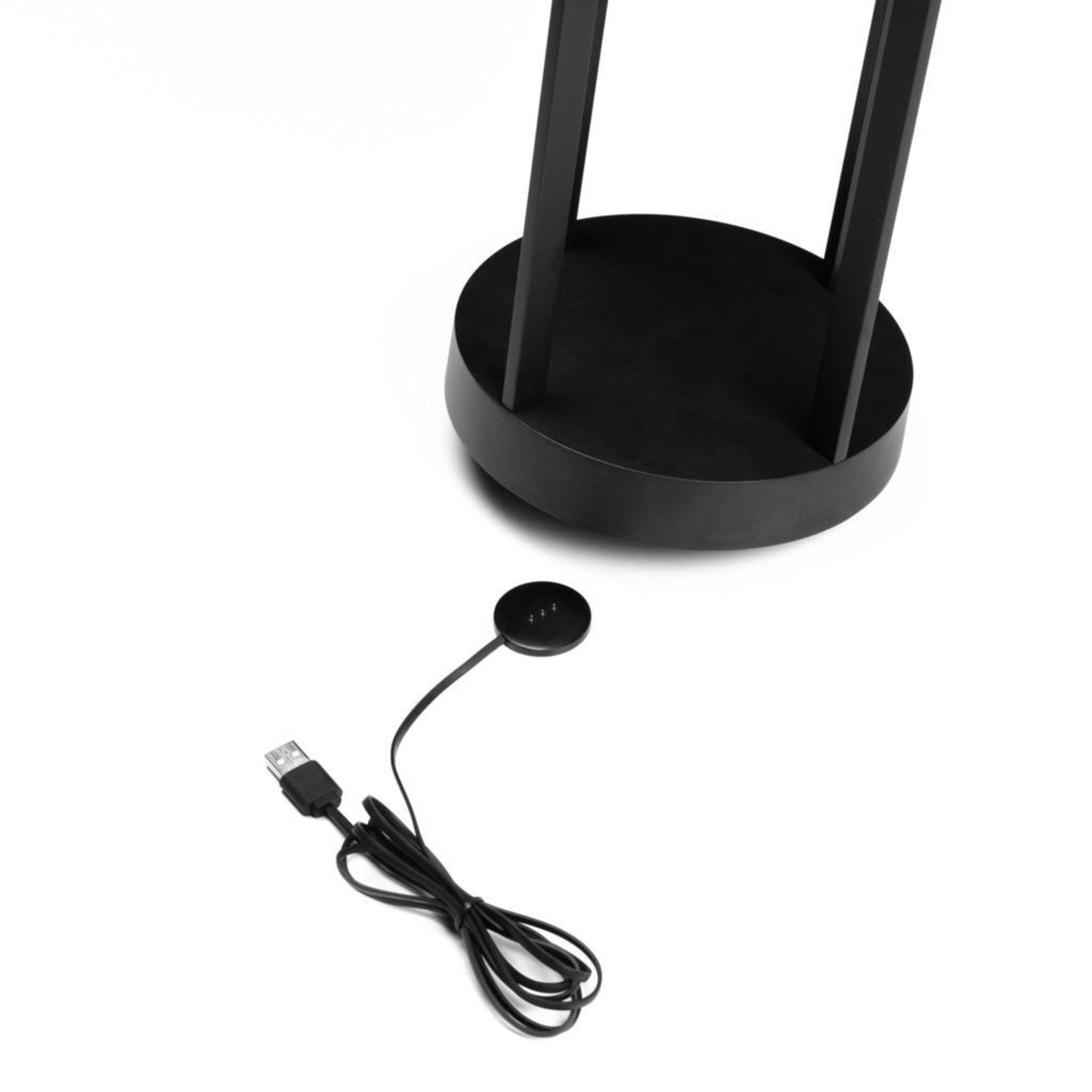 Schwarzer Fuß einer Stehlampe und eine Ladestation mit USB-Kabel.