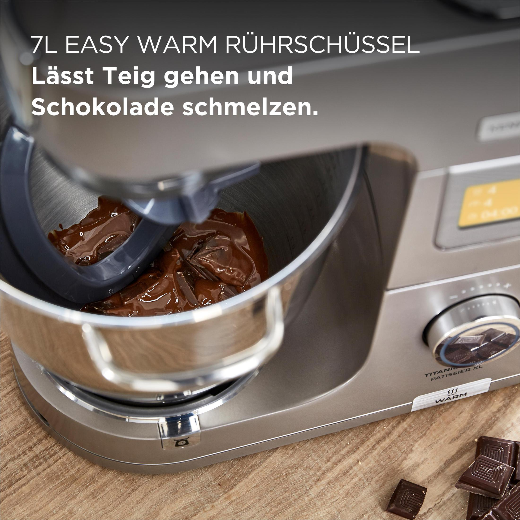 A silver mixer with chocolate in the bowl. The bowl contains a mixture with the word 'WARM'.