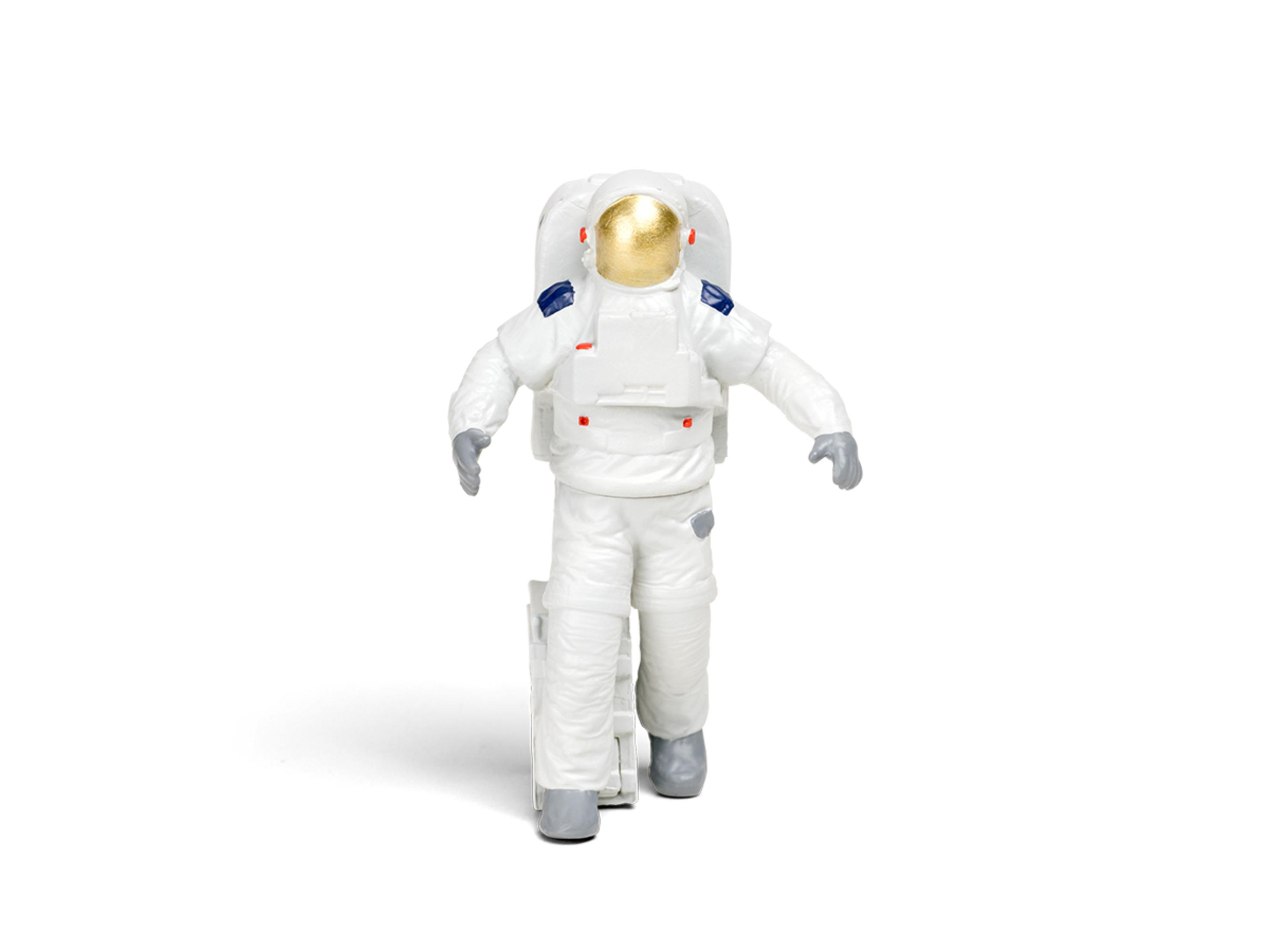 Spielzeug-Astronautenfigur in weißem Anzug und goldenem Helm, die eine kleine Leiter hält, isoliert auf Weiß.