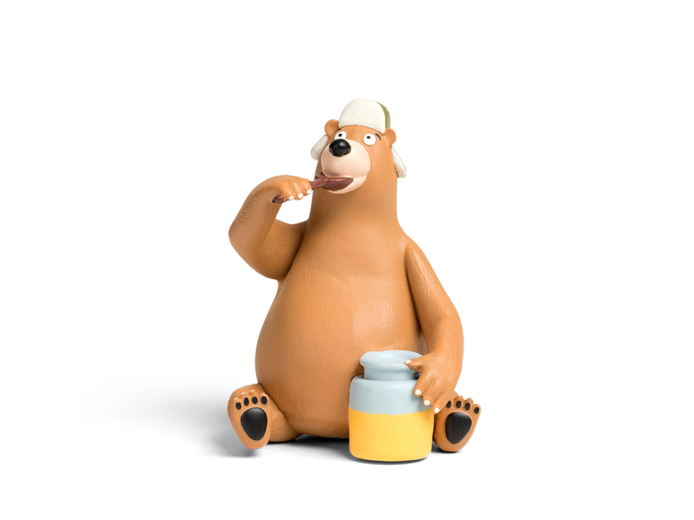 Zeichentrickbär sitzt, hält Honigglas, isst Honig mit einem Löffel. Isoliert auf weißem Hintergrund.