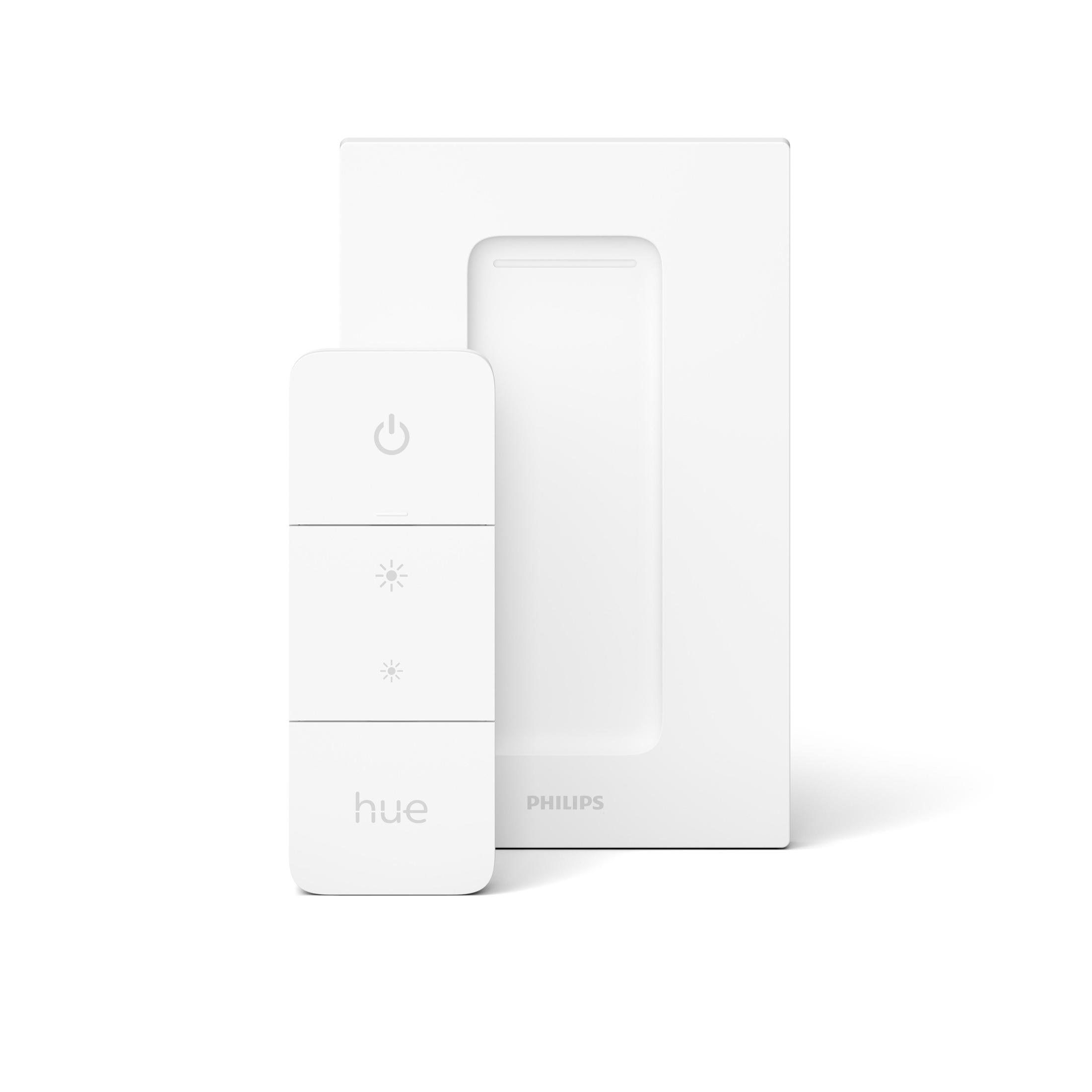 Télécommande et base Philips Hue blanches. La télécommande a trois boutons et est sur une surface blanche.