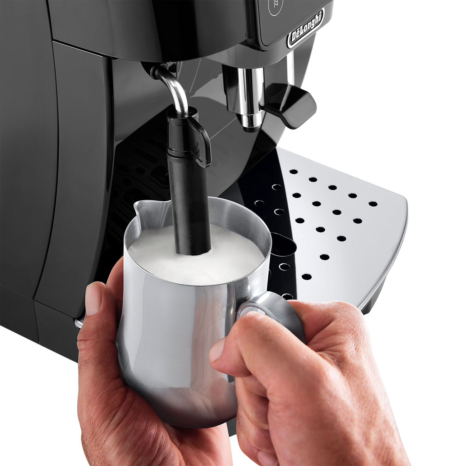 Hände halten einen silbernen Milchaufschäumer neben einer Kaffeemaschine.