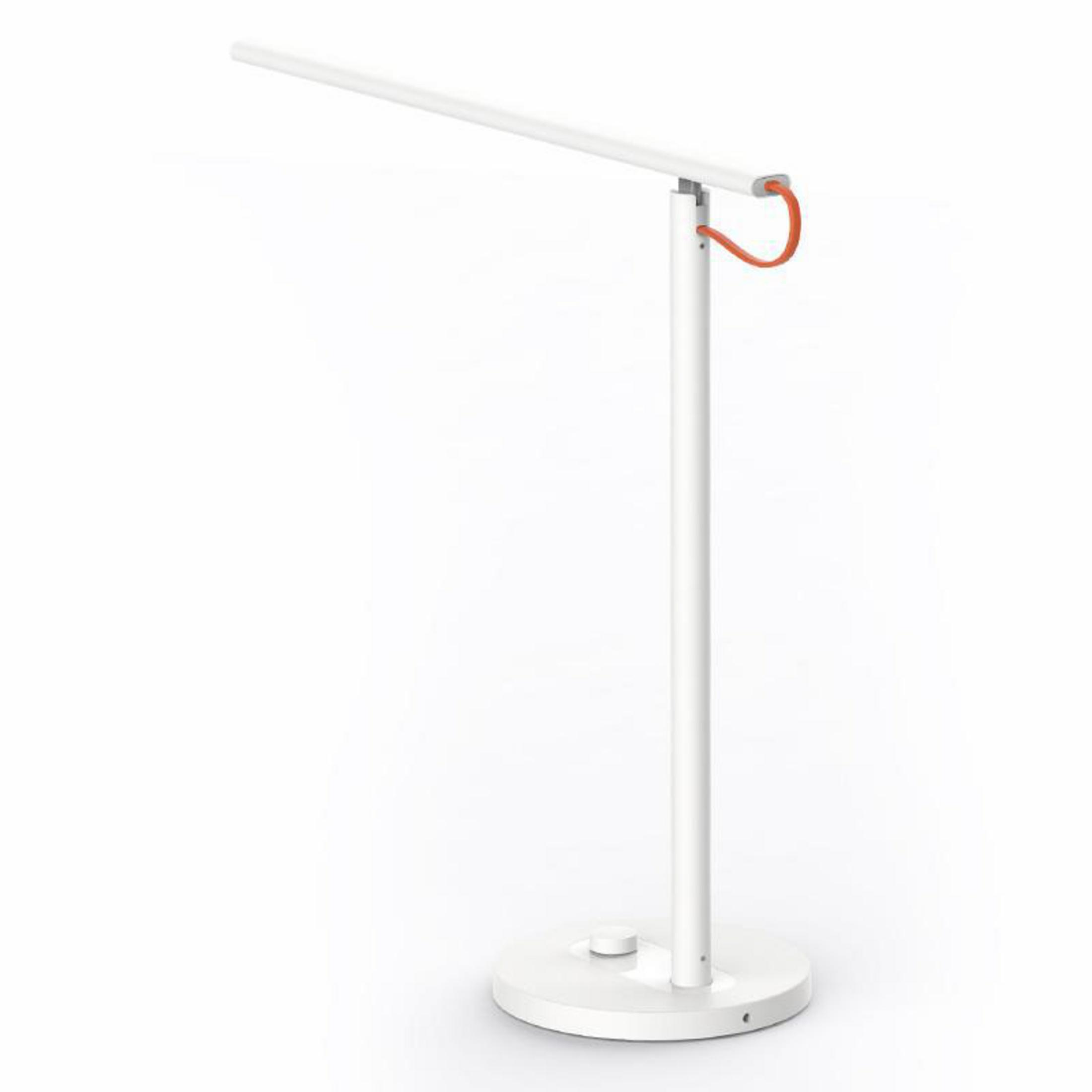 Lámpara de escritorio blanca con brazo curvo y cable rojo. Está sobre un fondo blanco.