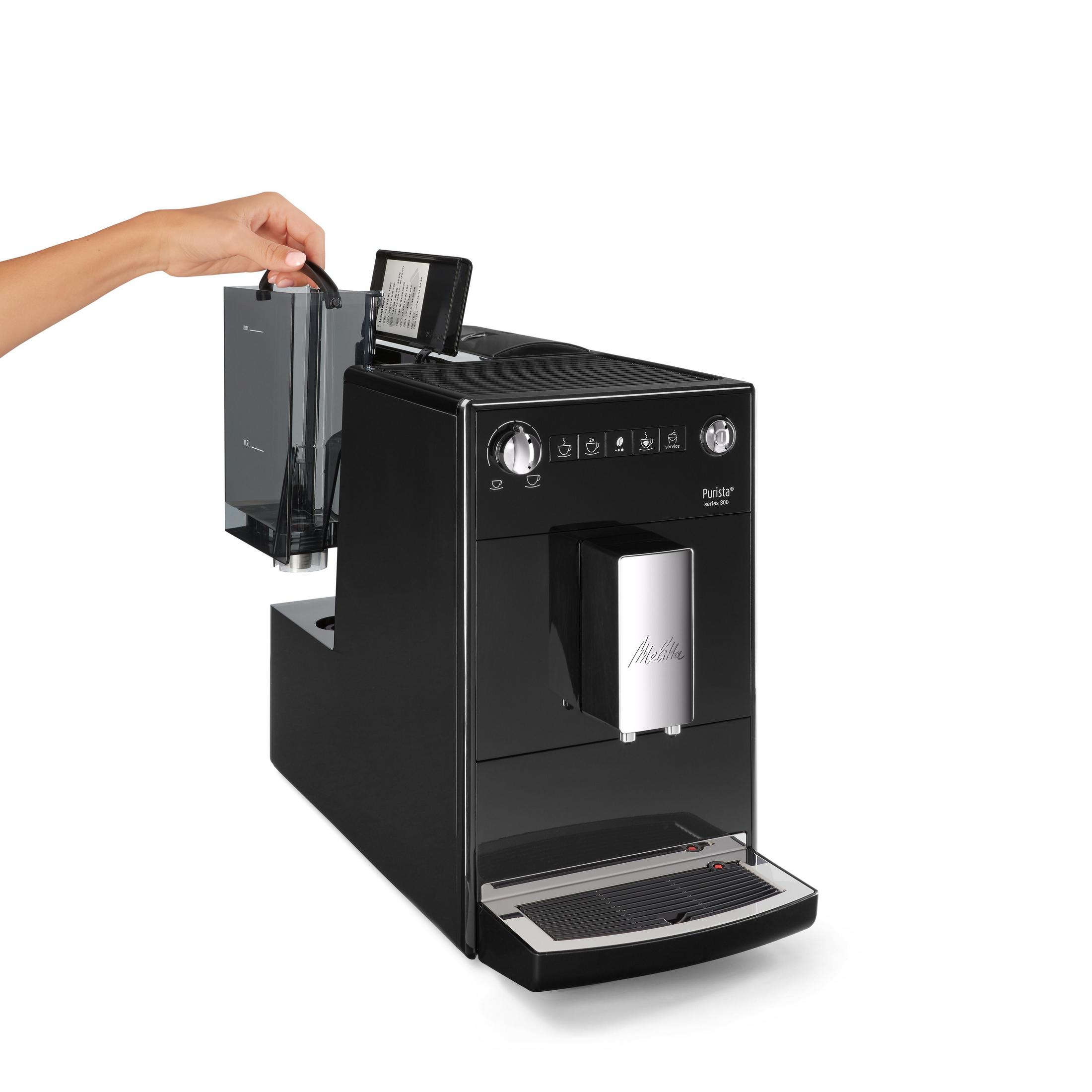 Czarny ekspres do kawy Melitta Purista. Ręka trzyma zbiornik na wodę.