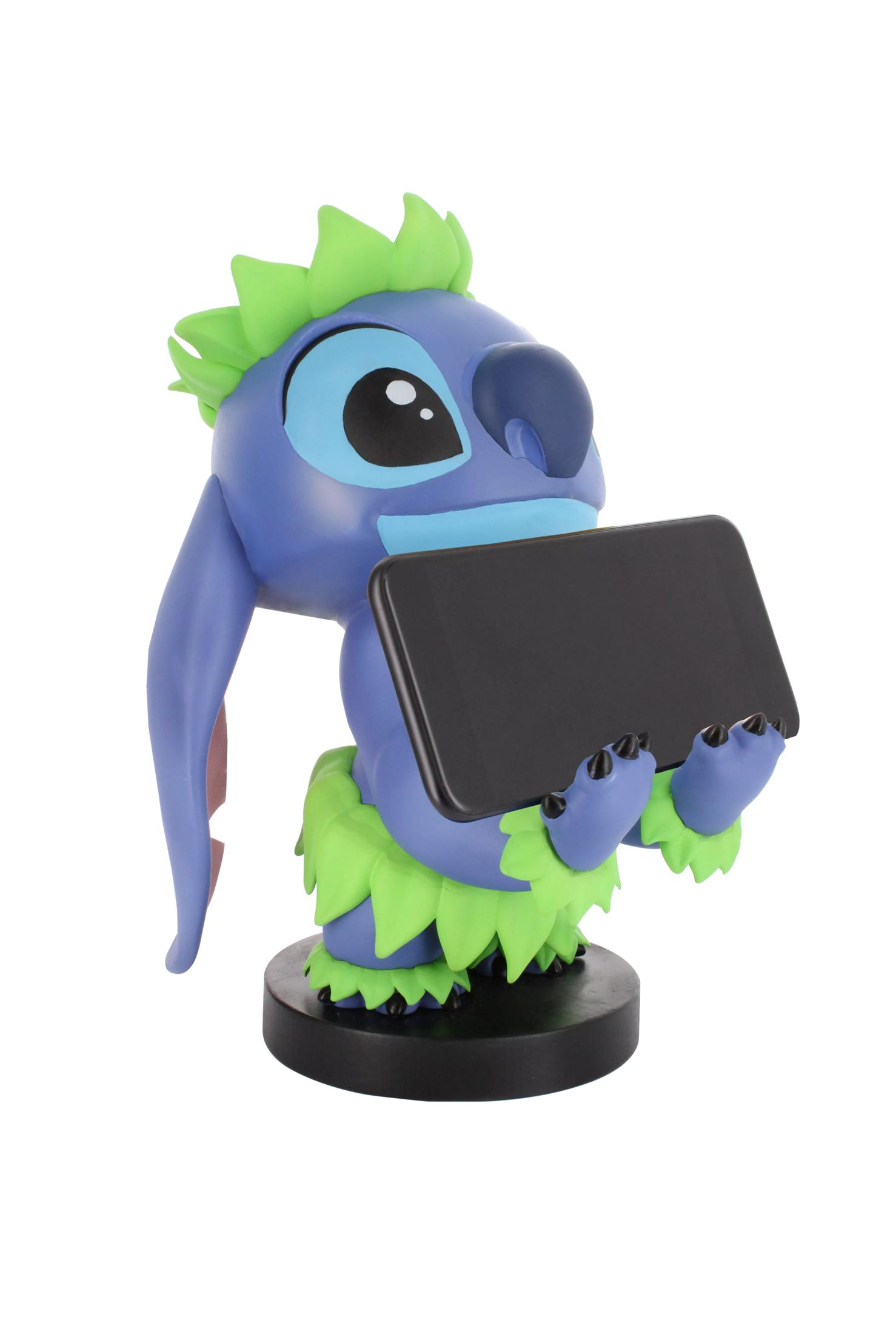 Figurka Stitch trzymająca czarny tablet. Stitch jest niebieski z dużymi uszami i zieloną spódnicą z trawy.