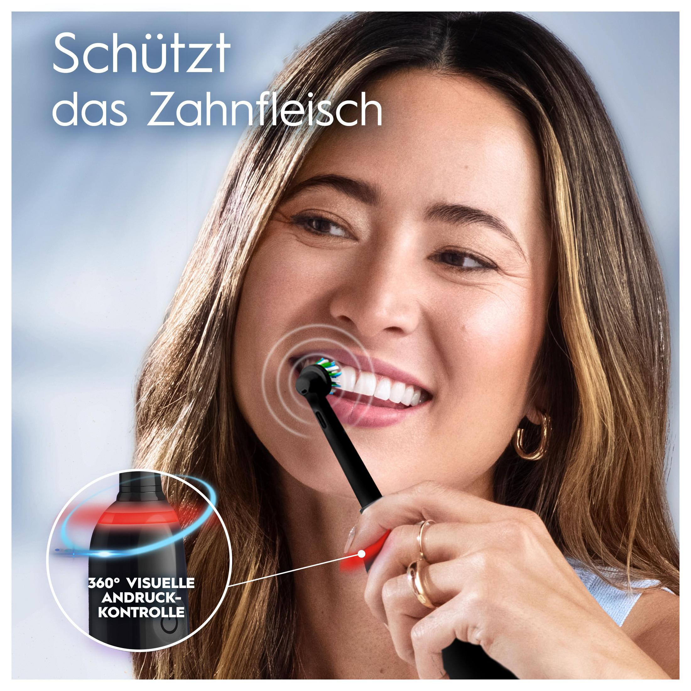 Mujer cepillándose los dientes con cepillo eléctrico negro. Luz roja en el cepillo, texto.