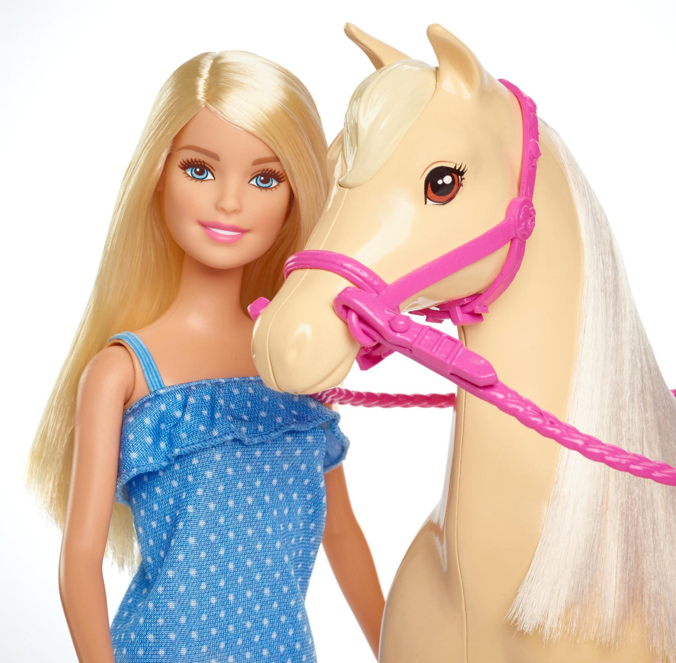 Barbie-Puppe mit blonden Haaren und blauem Kleid steht neben einem beigen Pferd mit rosa Zaumzeug.