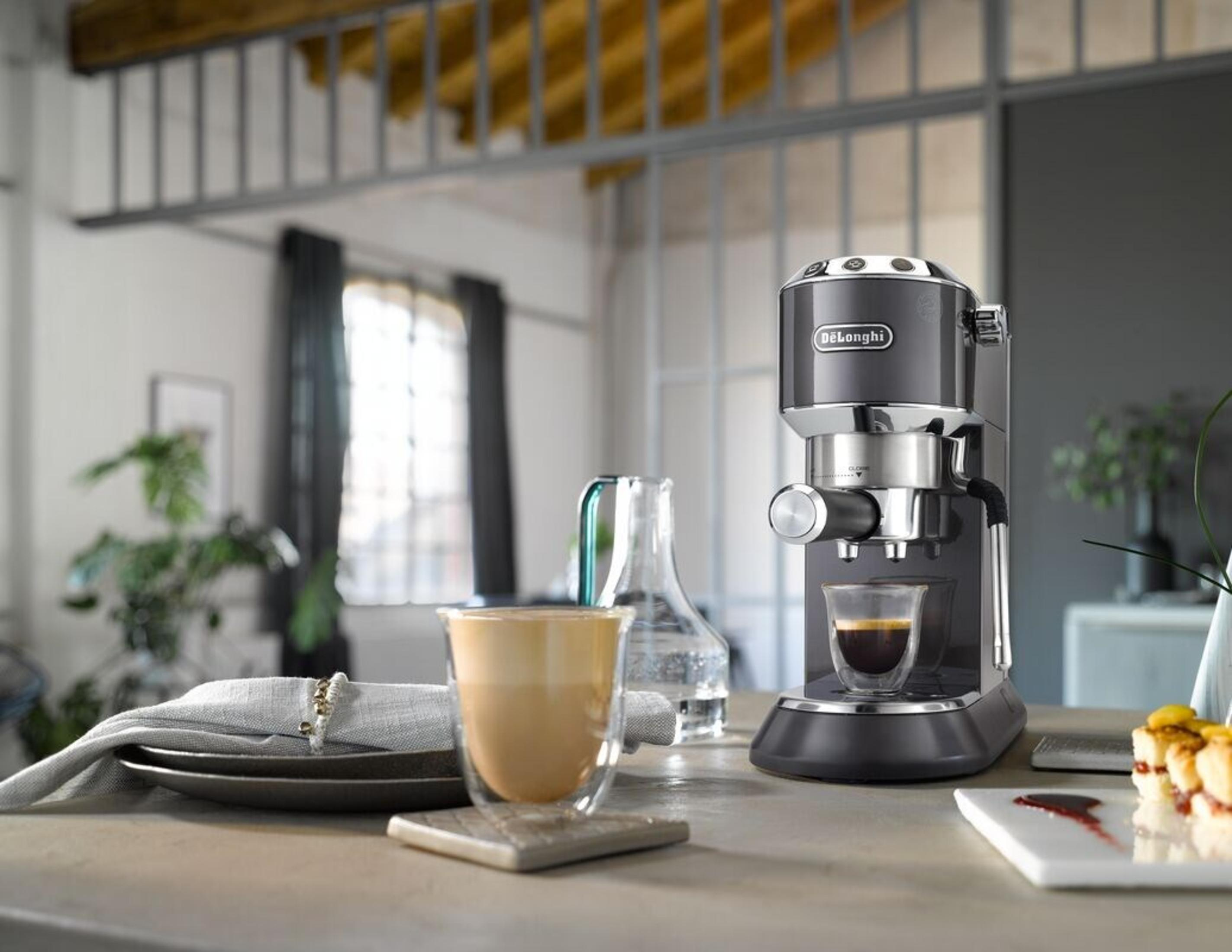 Una cafetera espresso con café, latte y accesorios en una encimera en un hogar moderno.
