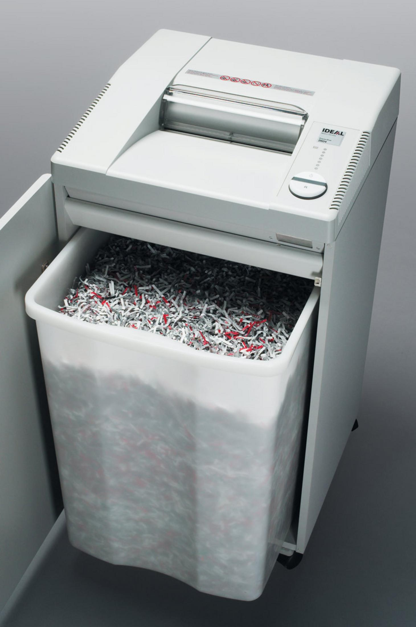 Ein Aktenvernichter mit vollem Papierkorb. Die Maschine ist weiß und der Behälter ist transparent.