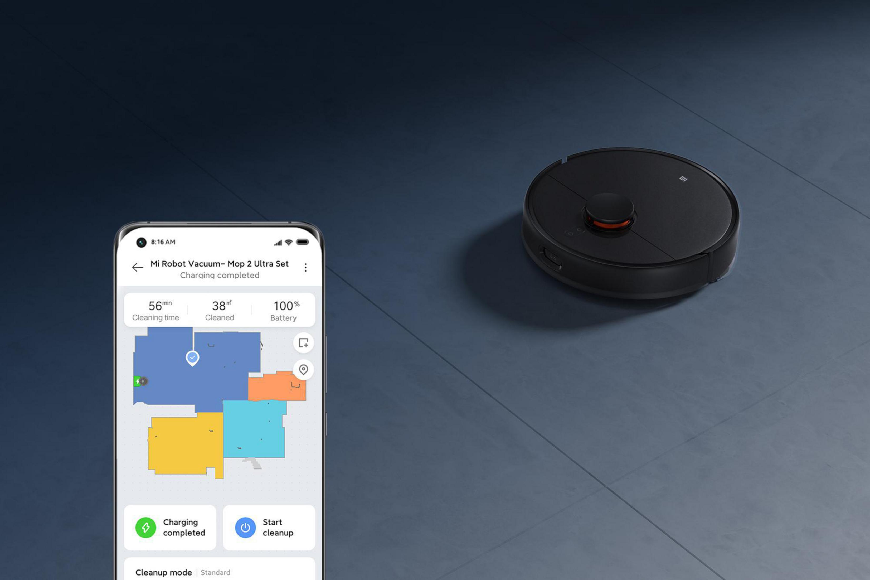 Robot aspirador y teléfono mostrando un mapa. El teléfono muestra estado de limpieza y batería.