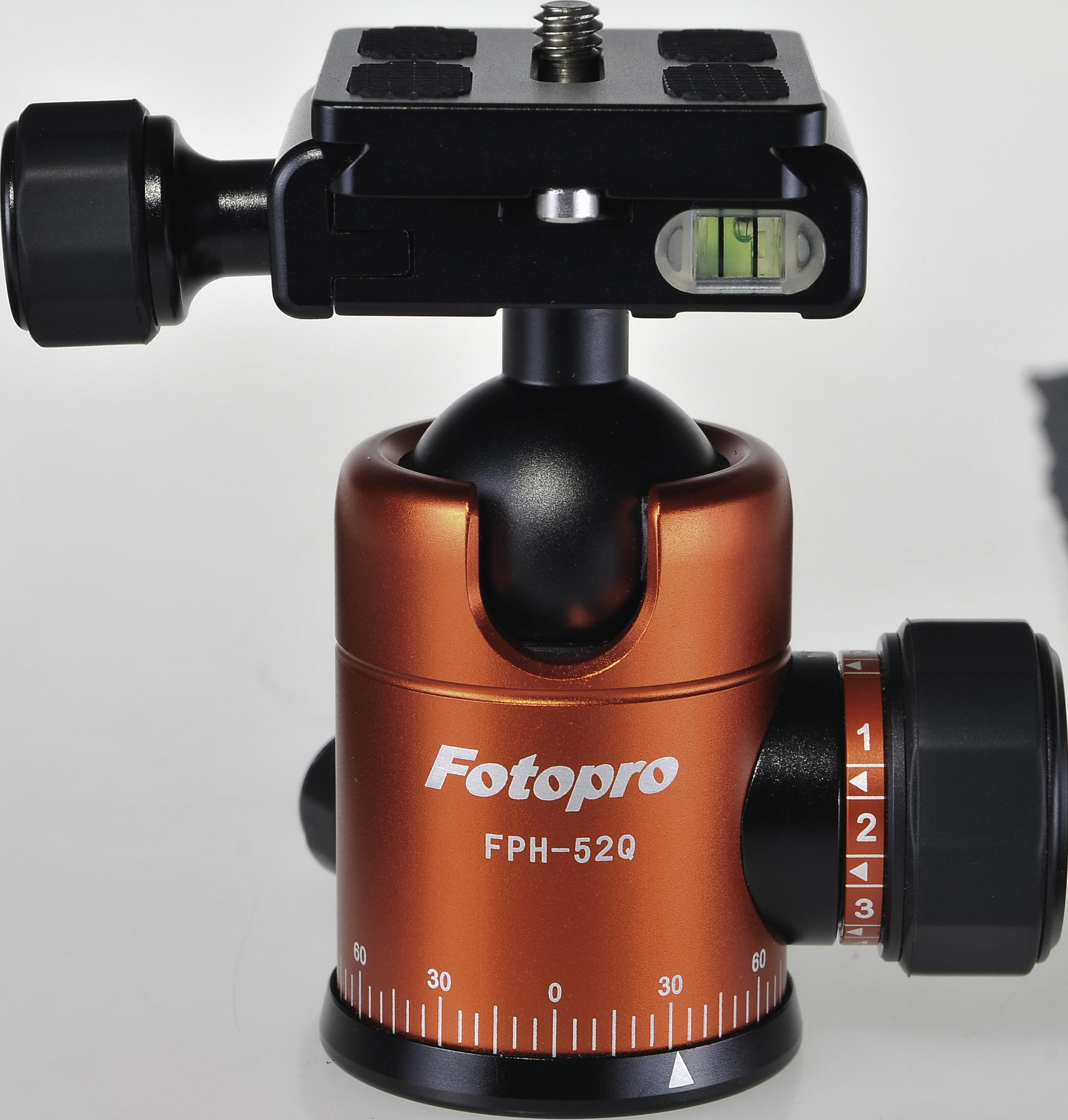 Pomarańczowa głowica statywu z tekstem Fotopro, czarnymi pokrętłami i poziomicą. Białe tło.