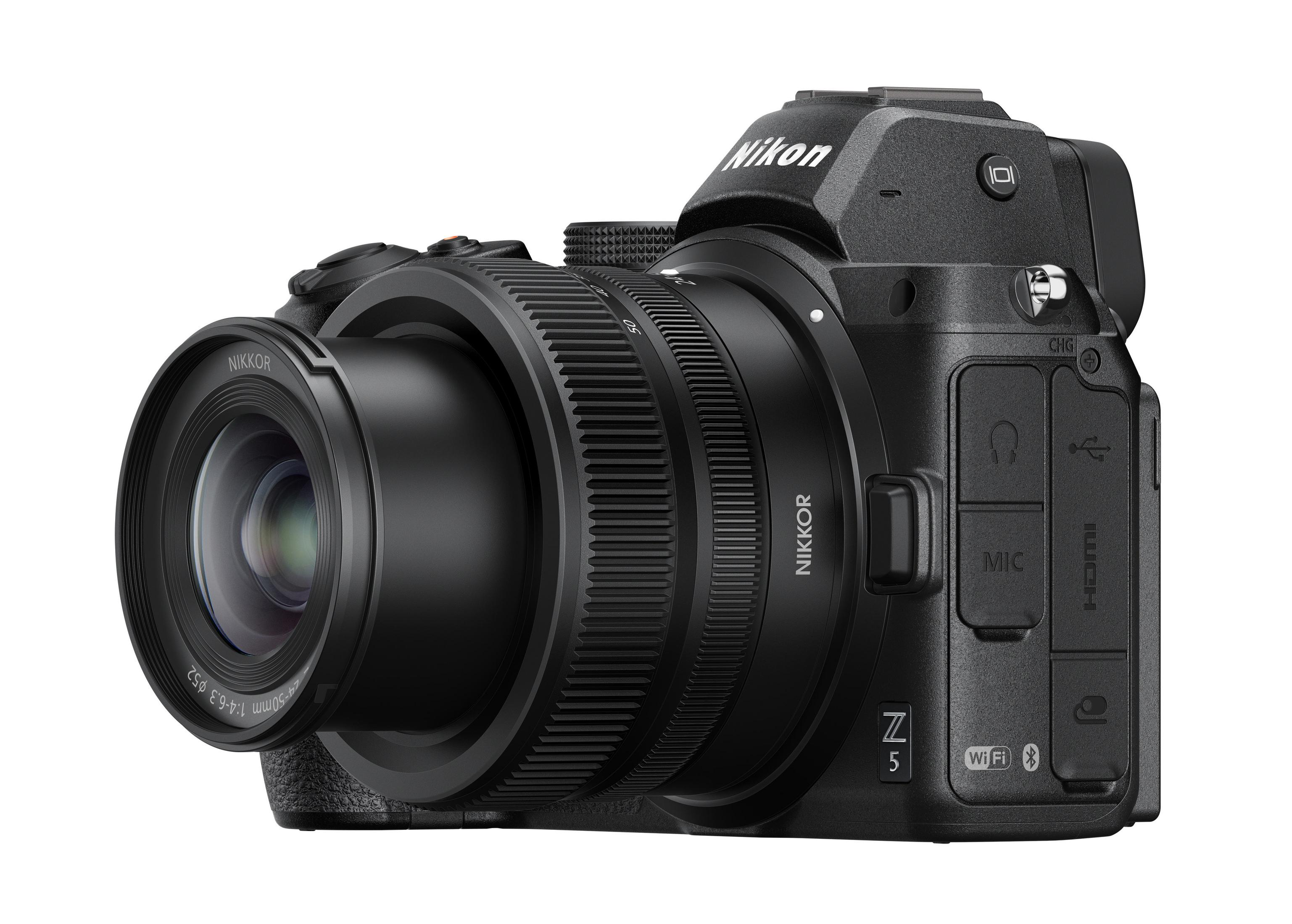 Aparat Nikon Z5 z dołączonym obiektywem, umieszczony na białej powierzchni, widok pod kątem.