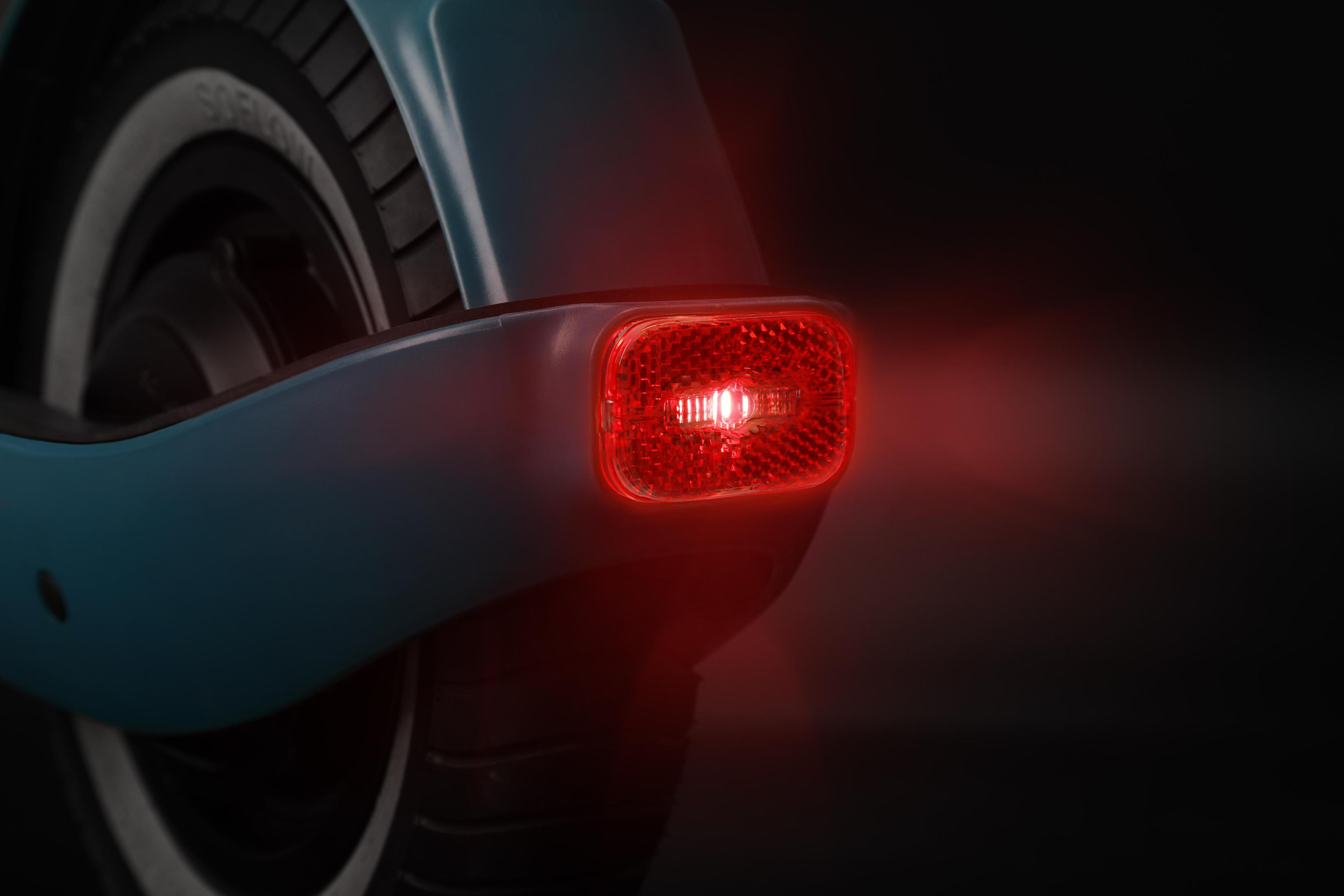 Roller-Rückseite, mit rot leuchtendem Reflektor, auf schwarzem Hintergrund.