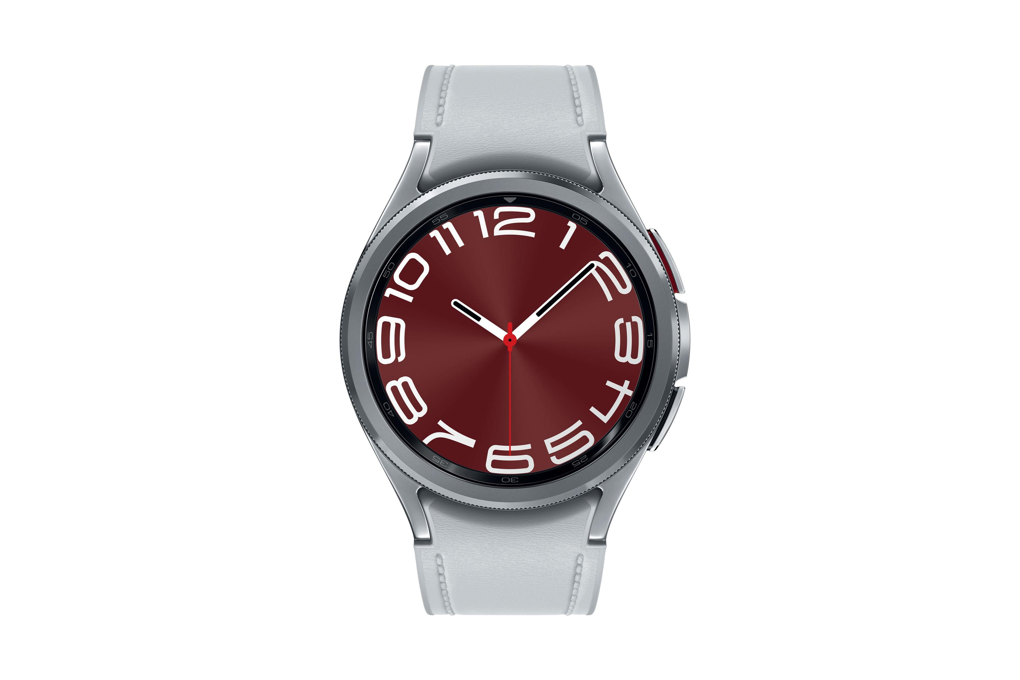 Smartwatch con cassa argentata e quadrante rosso, che mostra l'ora. Cinturino grigio chiaro. Sfondo bianco.