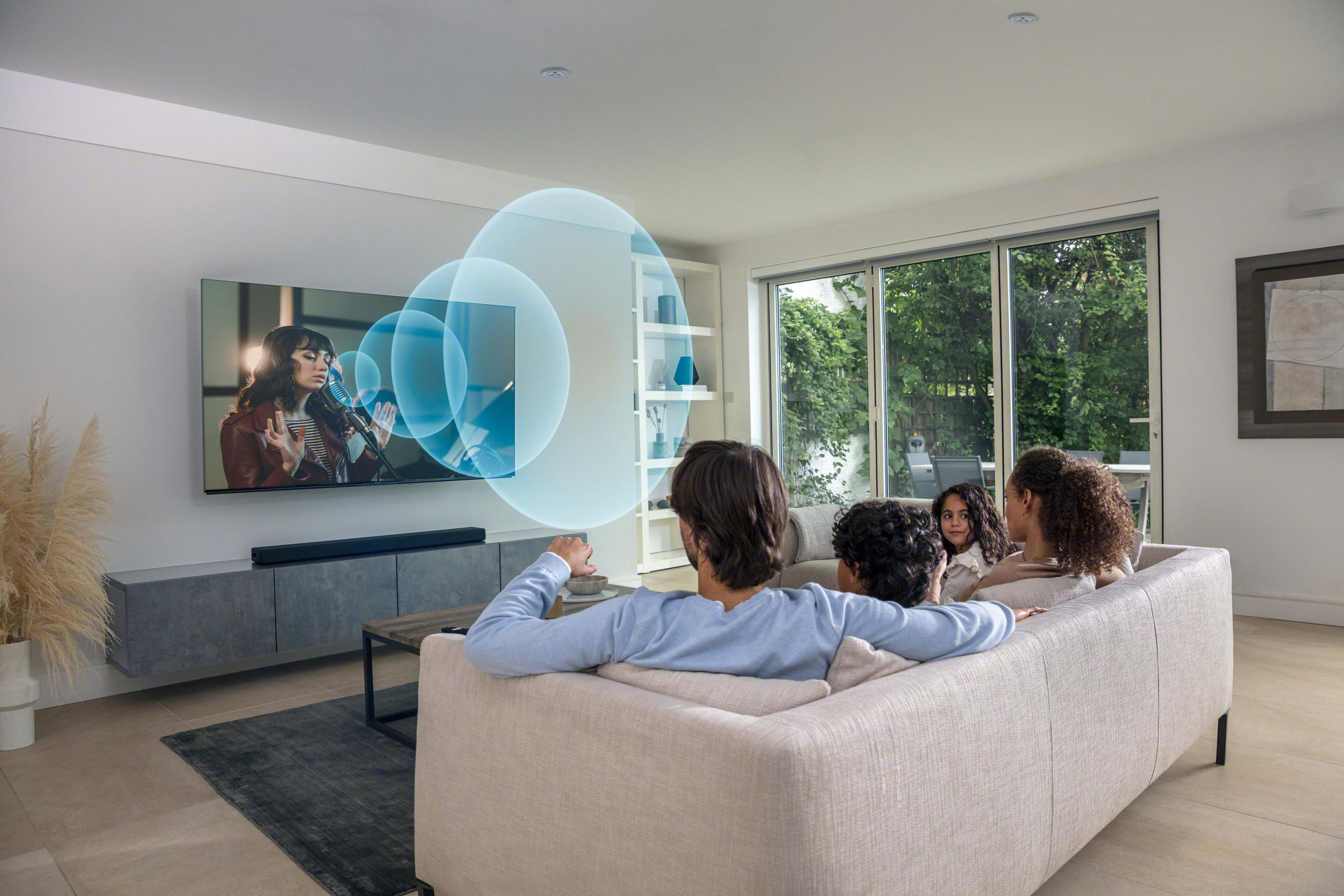 Familie sieht fern, mit Soundbar und visualisierten Schallwellen.