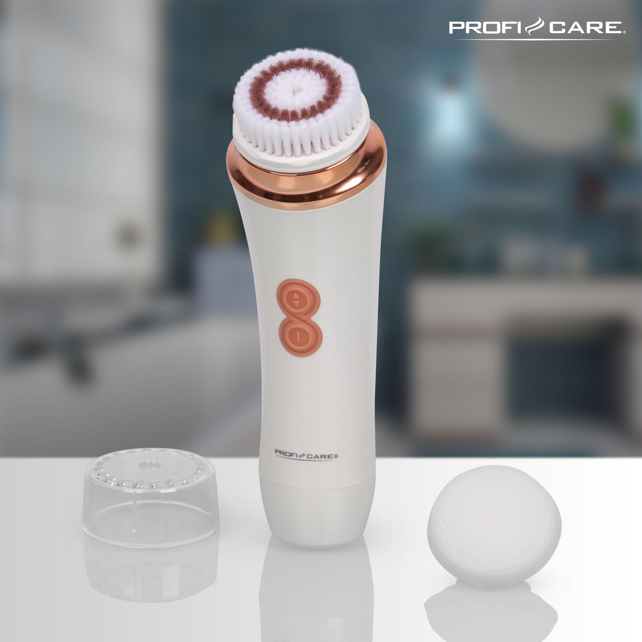 Biała i różowo-złota szczoteczka do oczyszczania twarzy z przezroczystą nasadką i gąbką. Rozmyte tło.