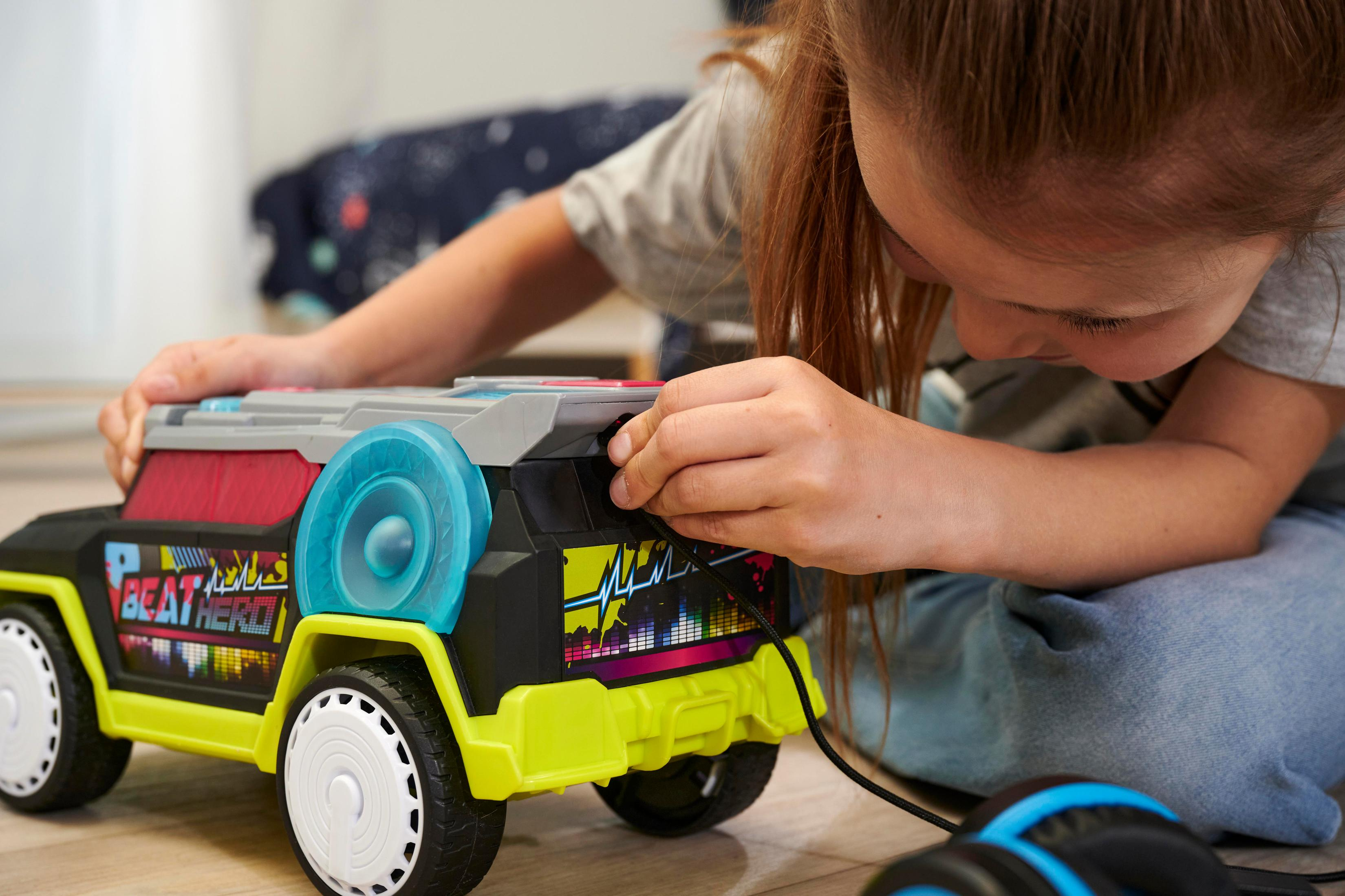 Dziewczynka bawi się zabawką w postaci samochodu z głośnikiem i światłami.