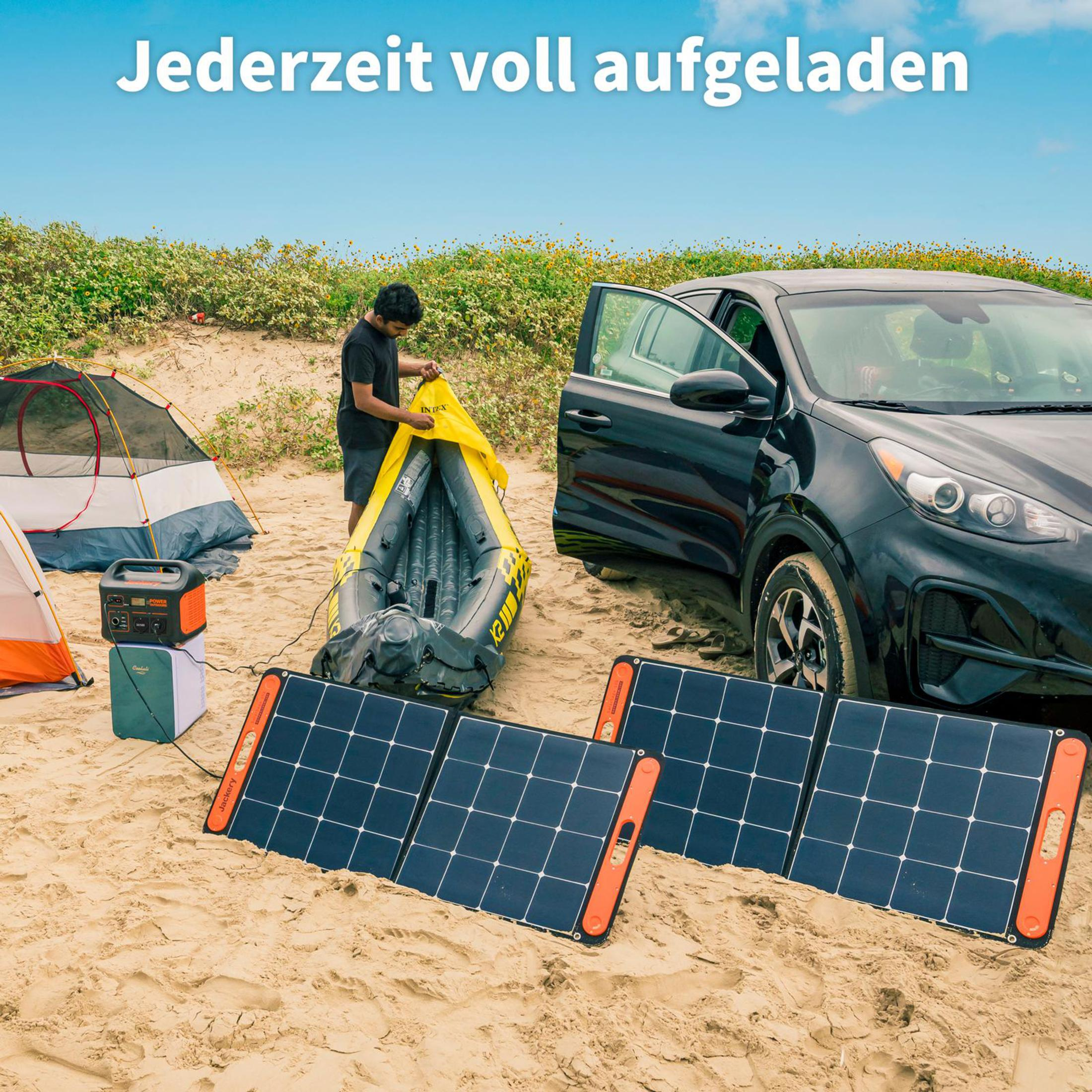 Een strandscène met zonnepanelen, een zwarte auto, een tent en een persoon die apparatuur opzet.