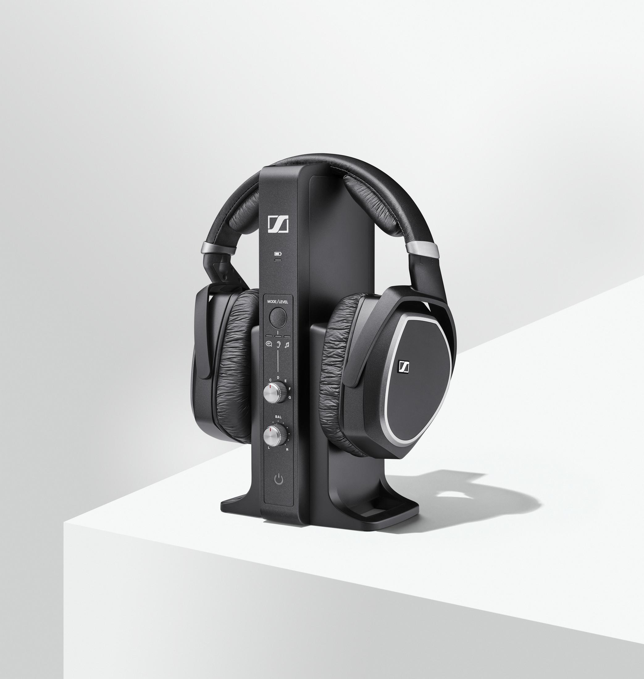 Auriculares Sennheiser negros en un soporte de carga. El soporte tiene un control de volumen.
