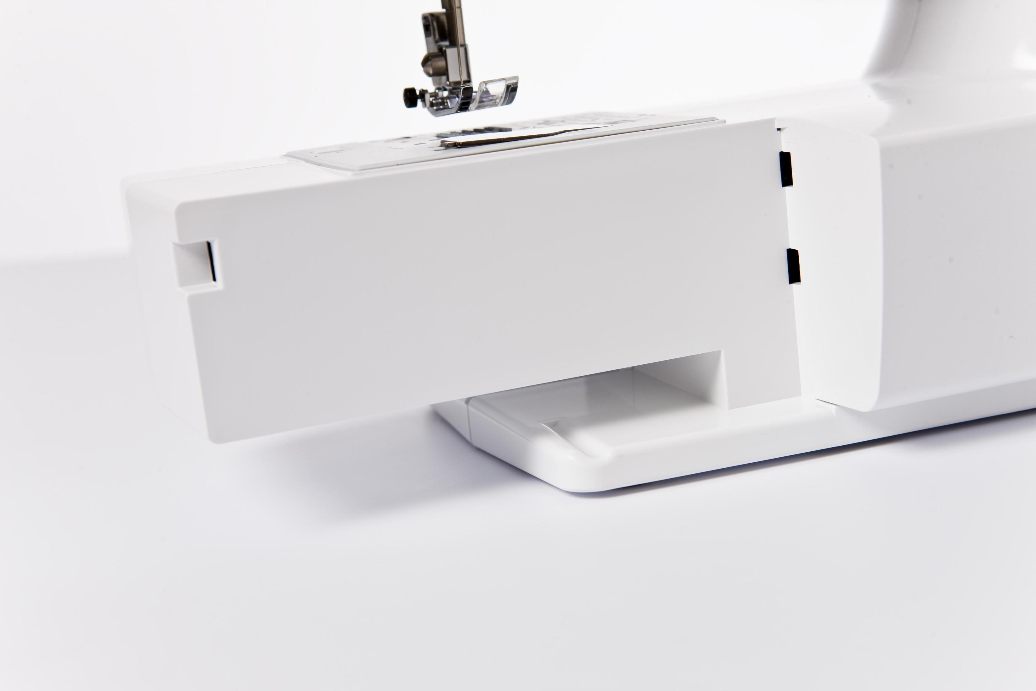 Podstawa białej maszyny do szycia, z wysuniętą sekcją, pokazującą przegródkę, na białym tle.