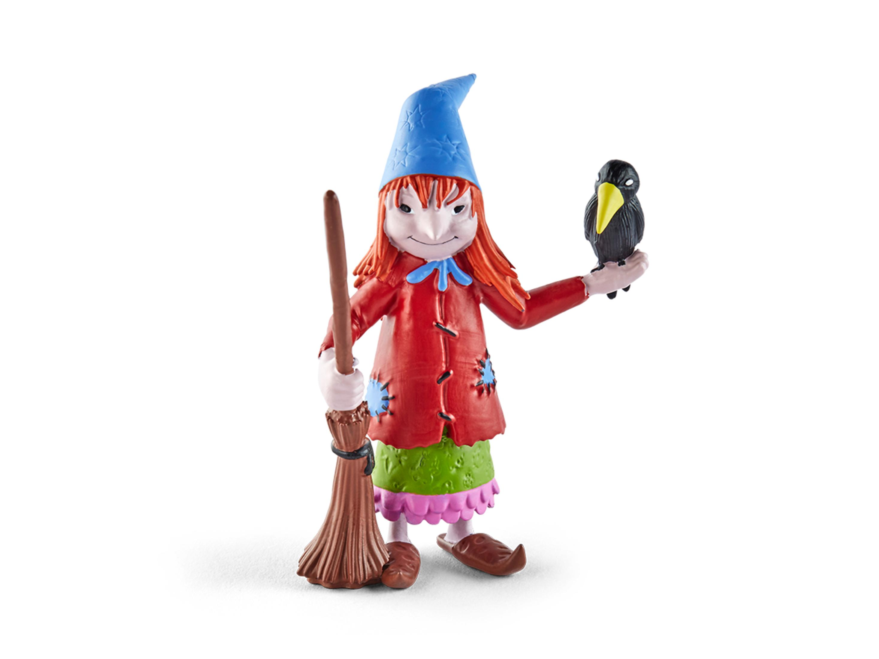 Eine Spielzeug-Hexenfigur, die einen Besen und eine schwarze Krähe hält, lächelt und einen Hexenhut trägt.