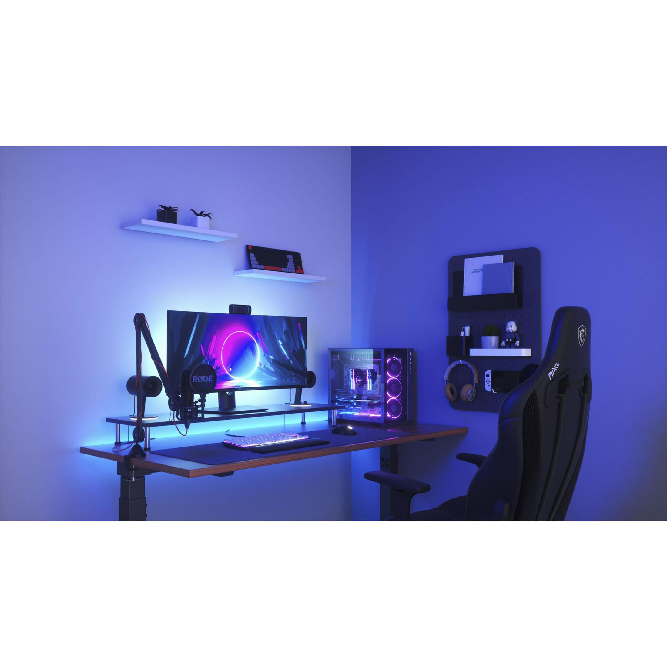 Configurazione di gioco: monitor, scrivania, microfono e sedia con illuminazione blu.