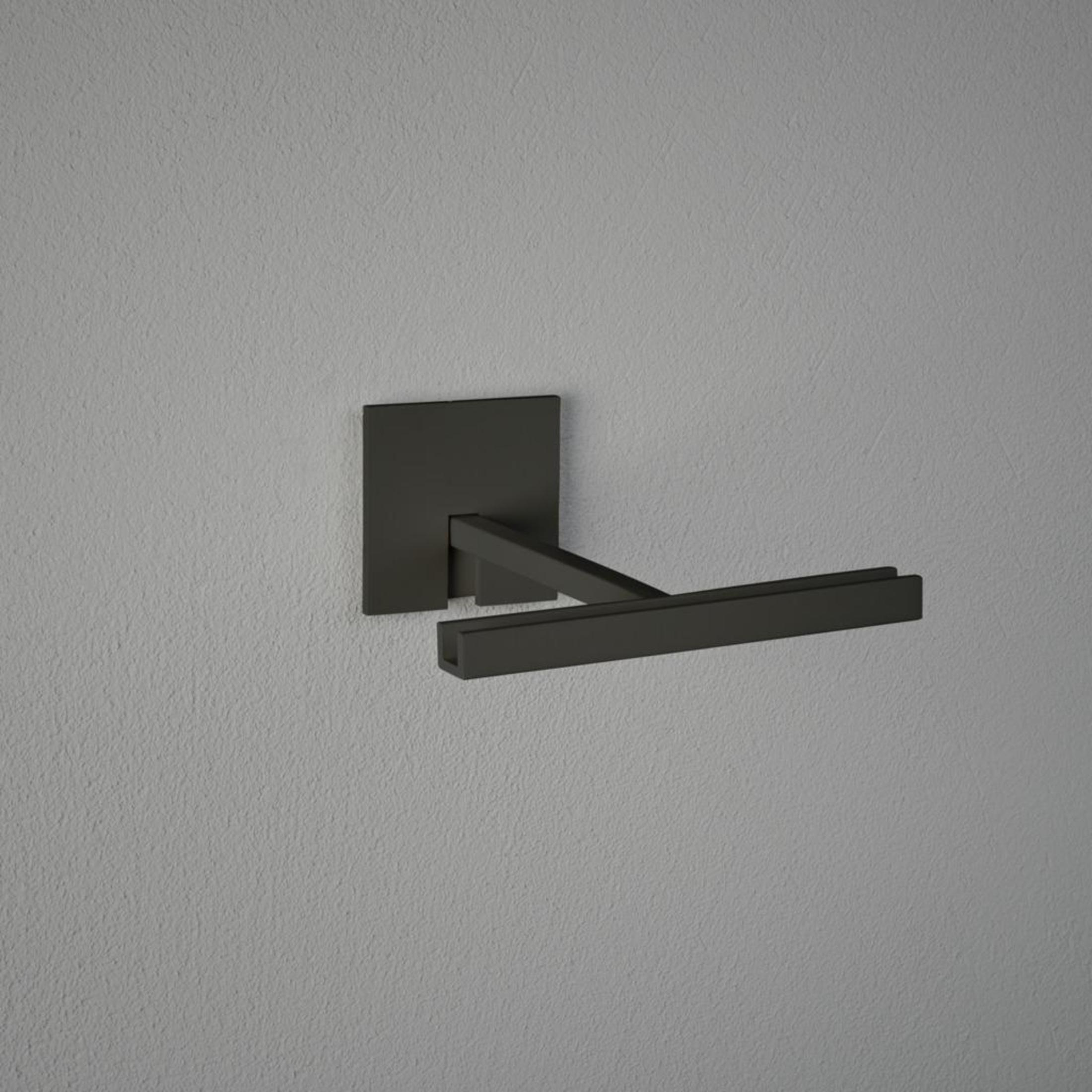 Ein schwarzer Handtuchhalter an einer grauen Wand, minimalistisches Design.