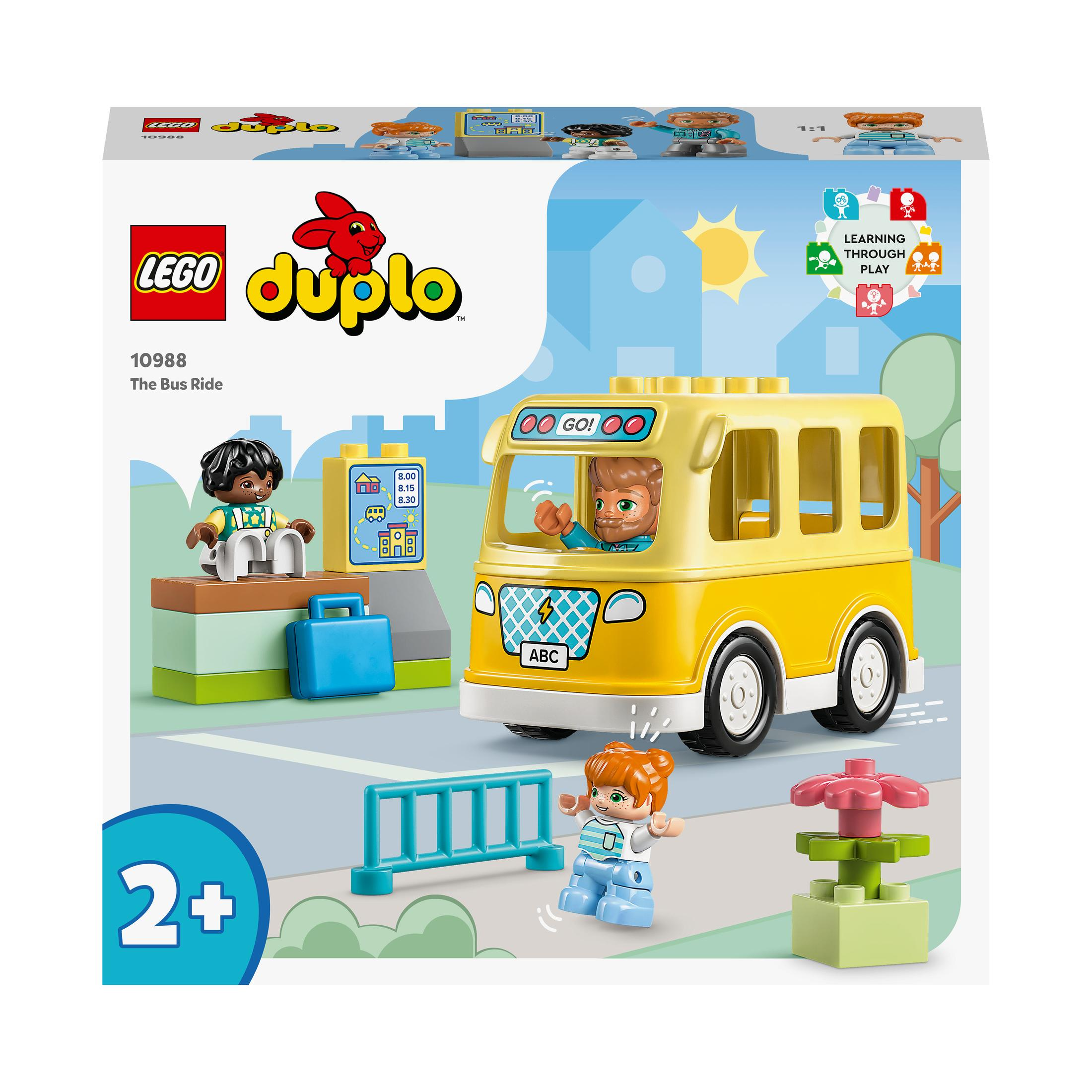Sarı bir otobüs, figürler ve bir otobüs durağı olan bir oyun sahnesi içeren bir Lego Duplo kutusu.