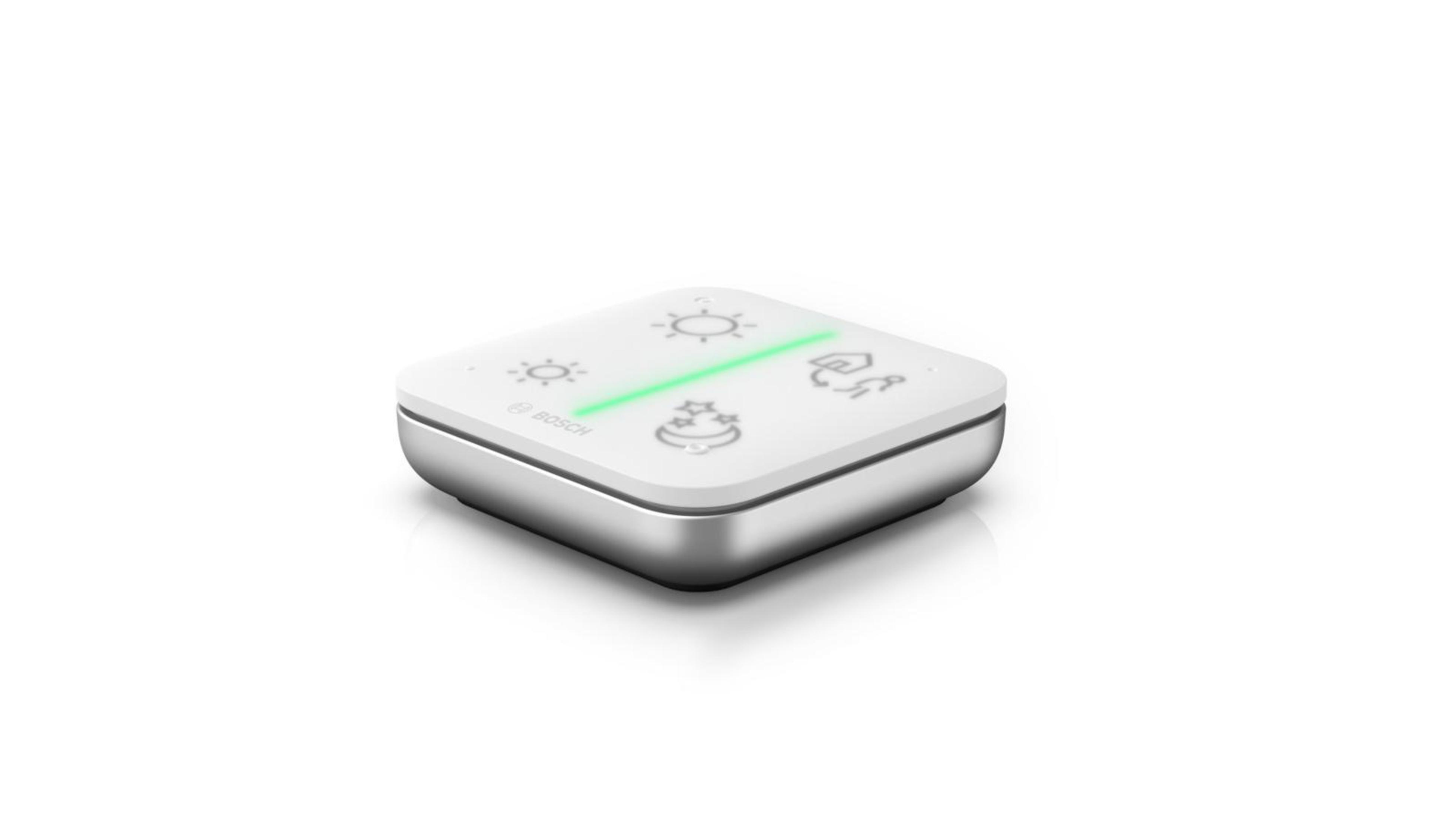 Ein weißes quadratisches Smart-Home-Gerät mit silbernem Rand und vier Symbolen, ein grünes Licht.