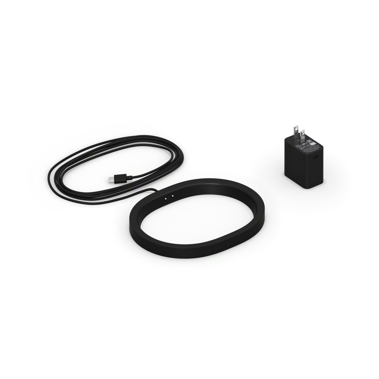 Czarny pierścień ładujący, kabel USB-C i czarny adapter ładujący na białej powierzchni.