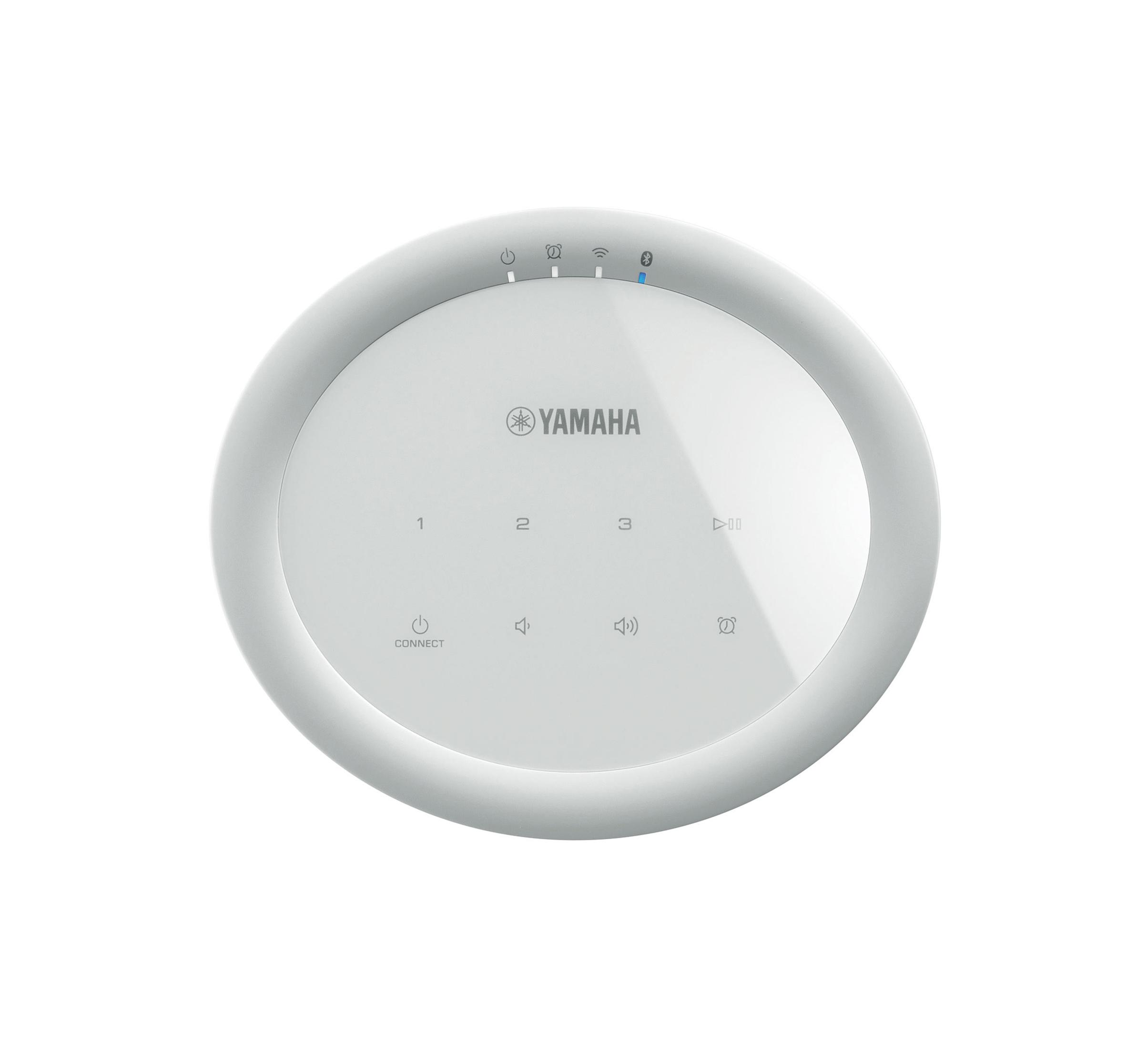 Białe urządzenie muzyczne Yamaha o okrągłym kształcie. Posiada przyciski zasilania, głośności i sterowania muzyką.
