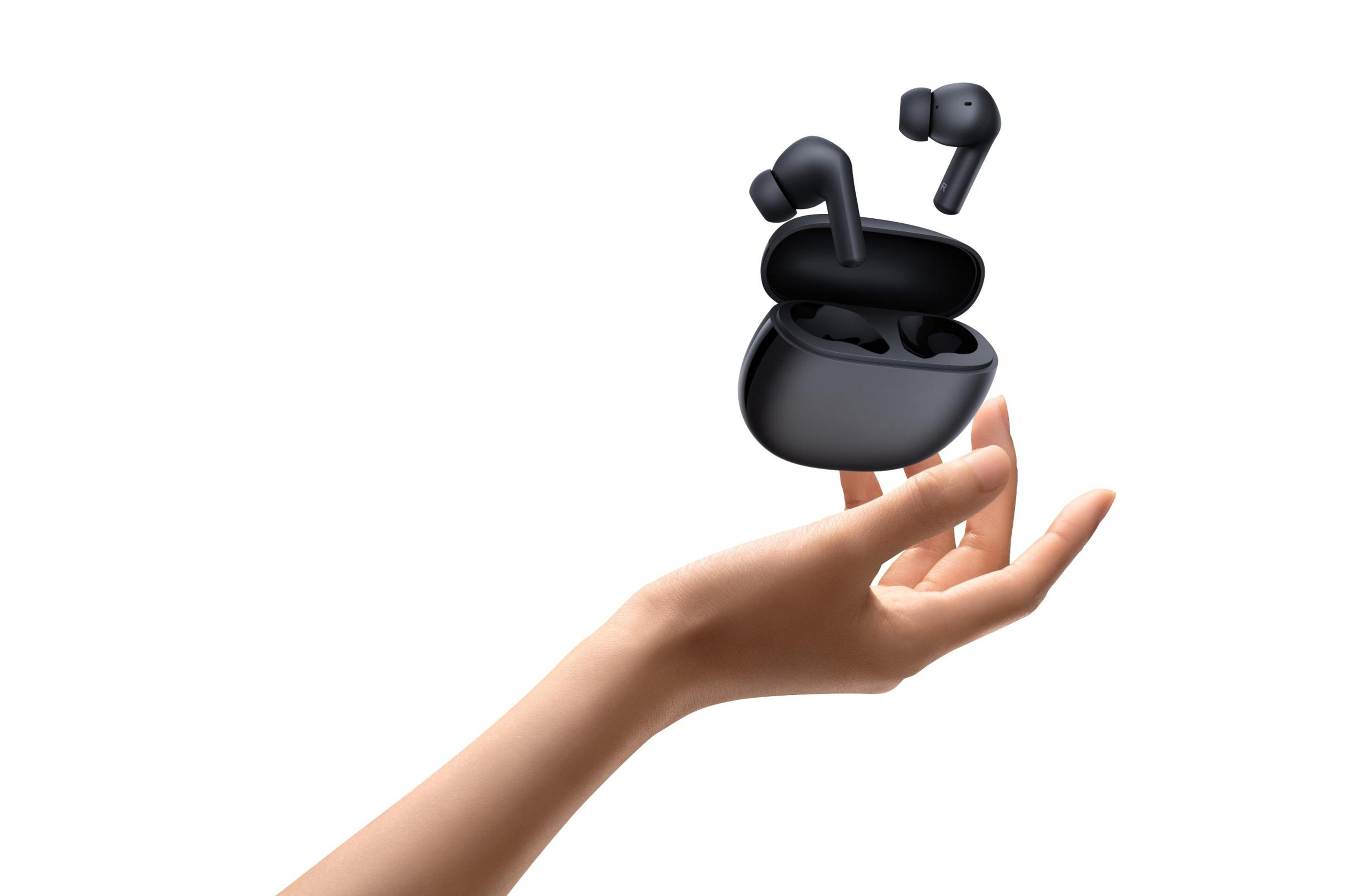 Czarne bezprzewodowe słuchawki i etui, unoszące się nad dłonią.