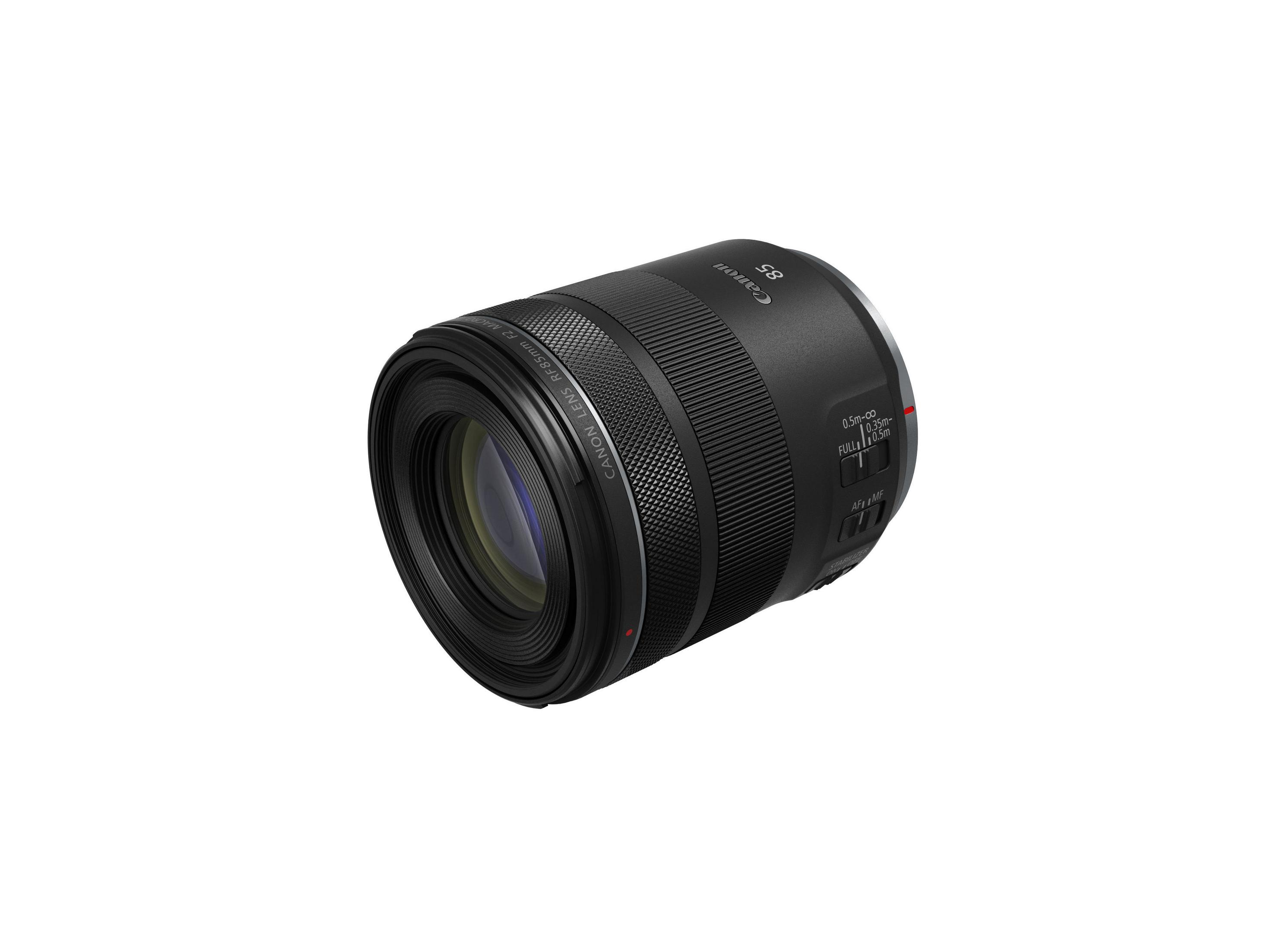 Black Canon 85mm lens with focus and aperture rings. It has a cylindrical shape and is on a white background.