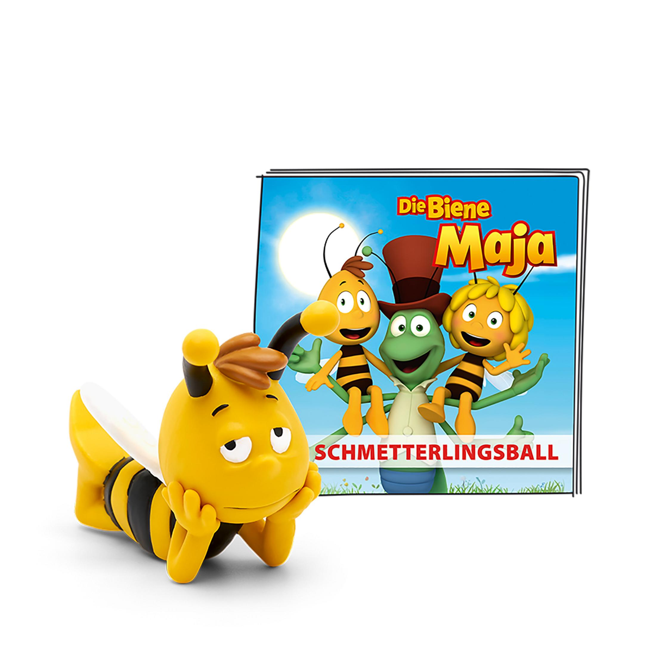 Bienenförmiges Spielzeug neben einem Buch, mit drei Zeichentrickfiguren auf dem Cover.